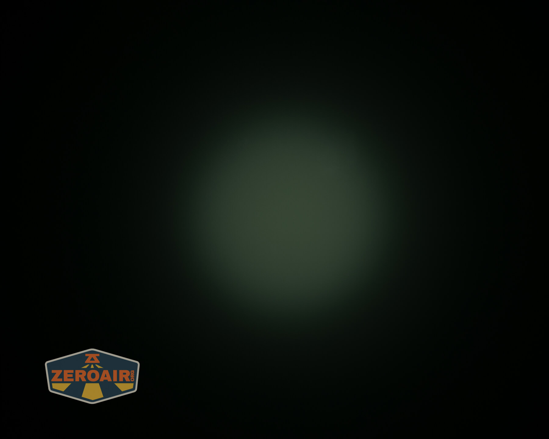 A circular, dim green glow appears in the center of a dark background. The ZeroAir logo is visible in the lower left corner.