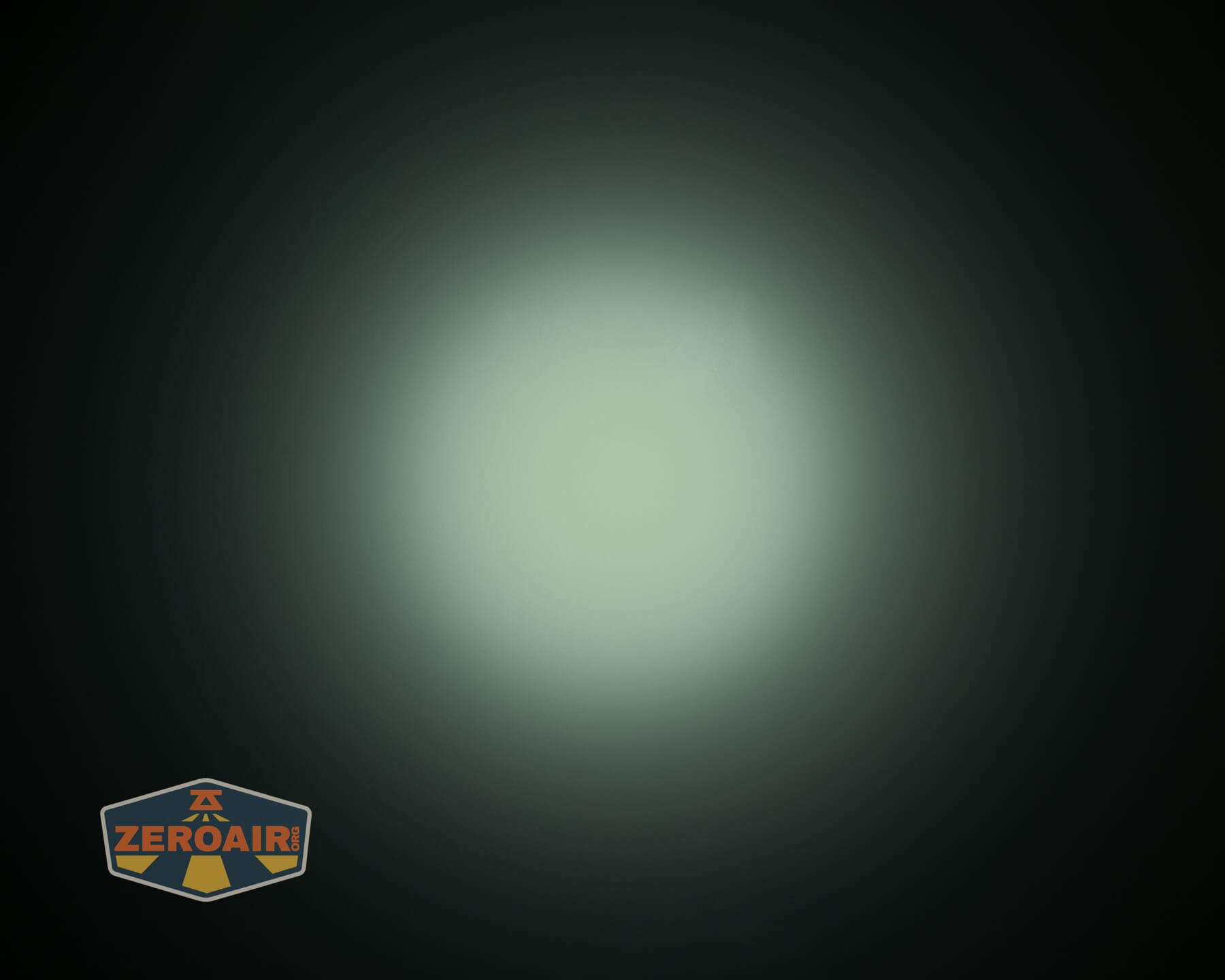 A circular white light is centered against a dark background, gradually fading to black at the edges. A logo with the text “ZEROAIR” is in the lower-left corner.