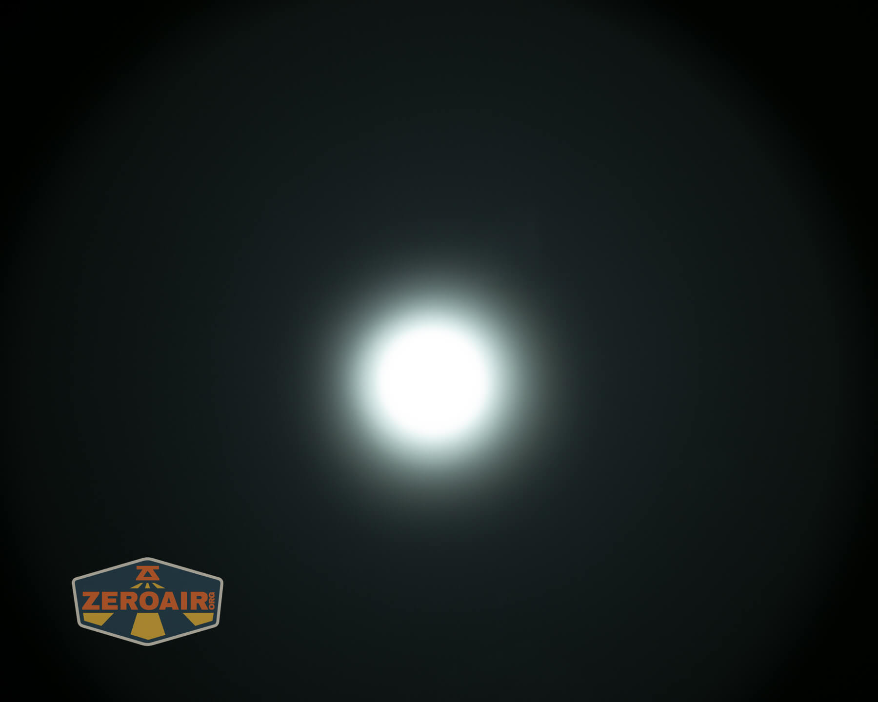 A bright white light is centered against a dark background with a subtle halo effect. In the lower left corner, there is a ZeroAir logo.