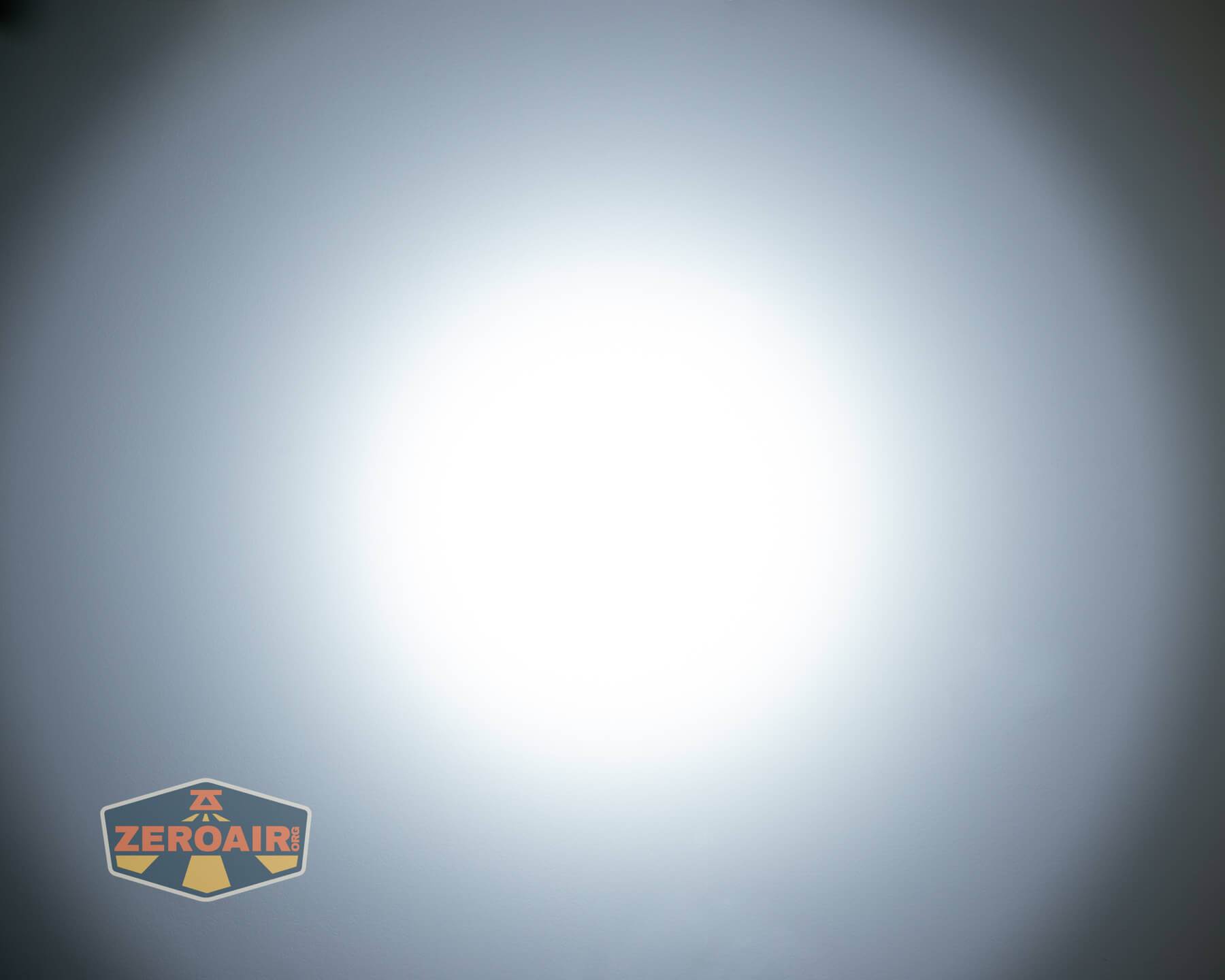 A bright white circular light is centered in the image, gradually fading to gray at the edges. A logo with the text ZEROAIR appears in the bottom left corner.
