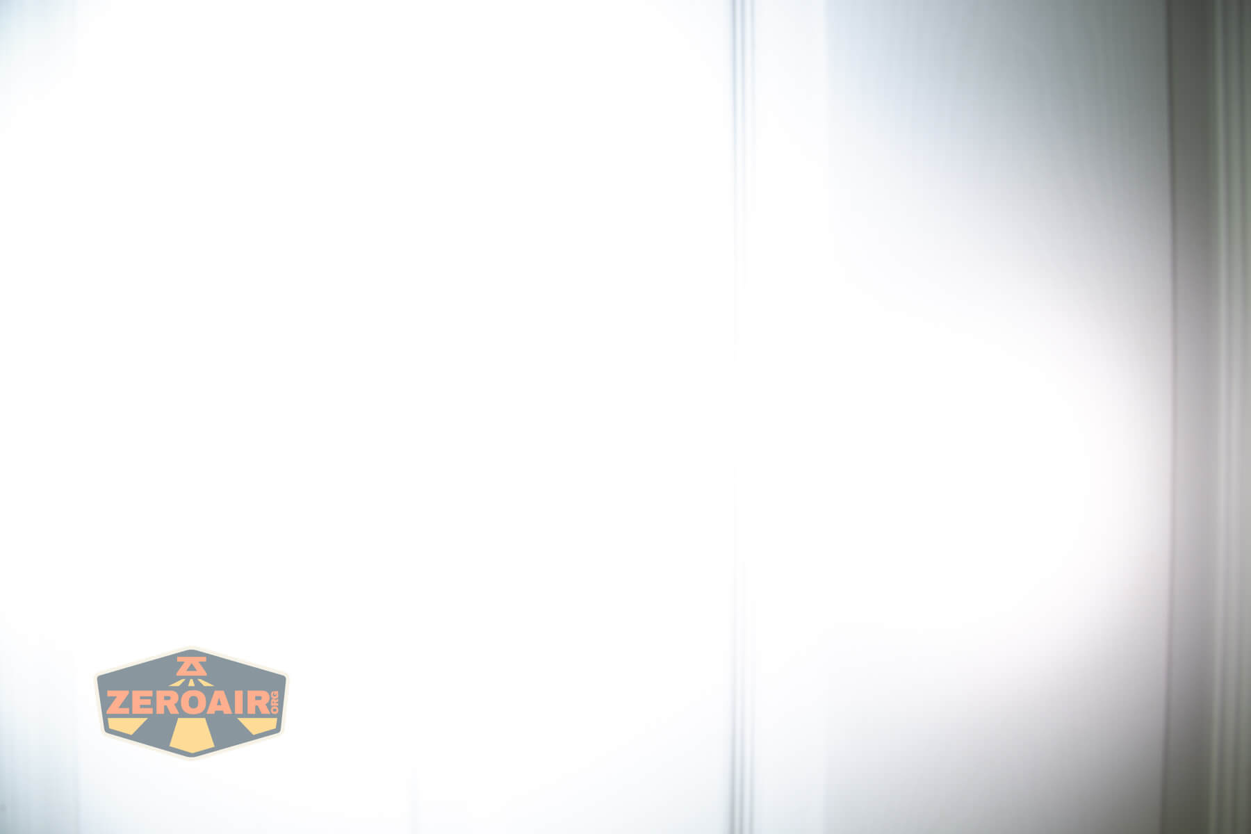 A brightly lit, overexposed surface with vertical lines, possibly a door or wall, is shown. The ZeroAir logo appears in the lower left corner.