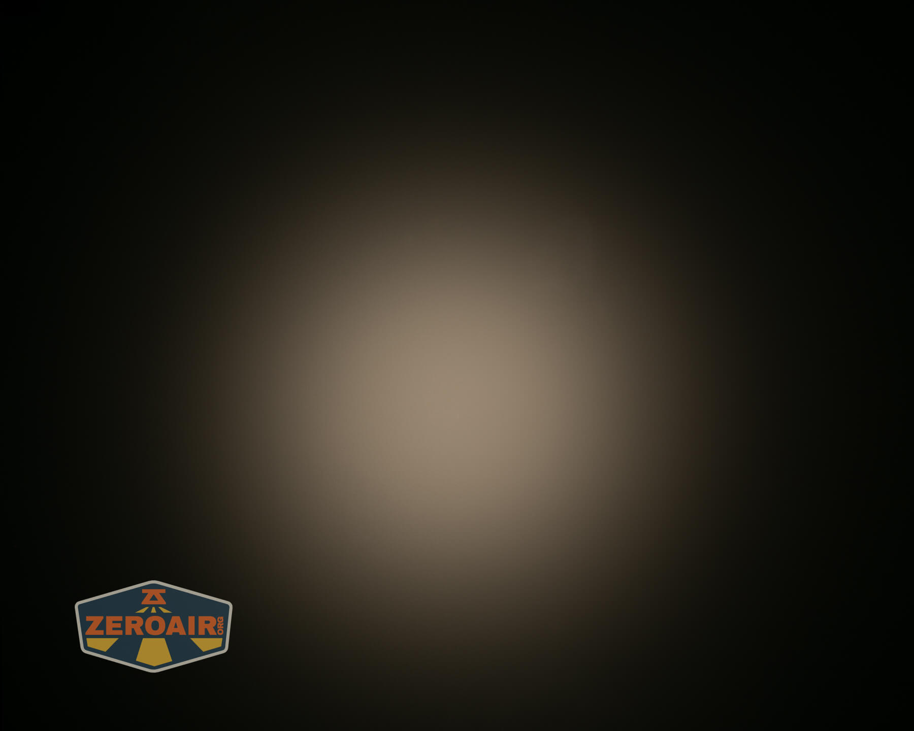 A circular beam of warm, diffused light is centered against a dark background. In the bottom left corner, there is a small ZeroAir logo with an orange and gray color scheme.
