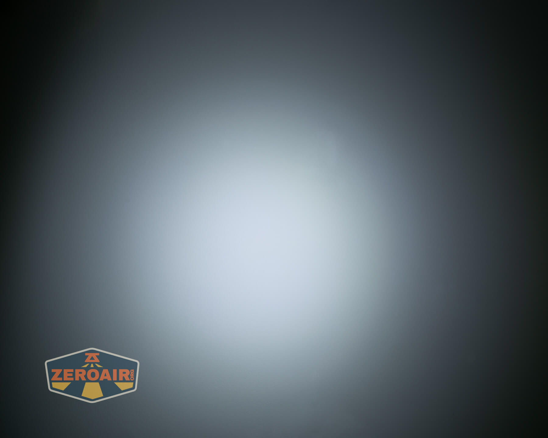 A circular, white beam of light appears centered against a dark background. In the lower left corner, there is a logo with the text ZEROAIR on it.