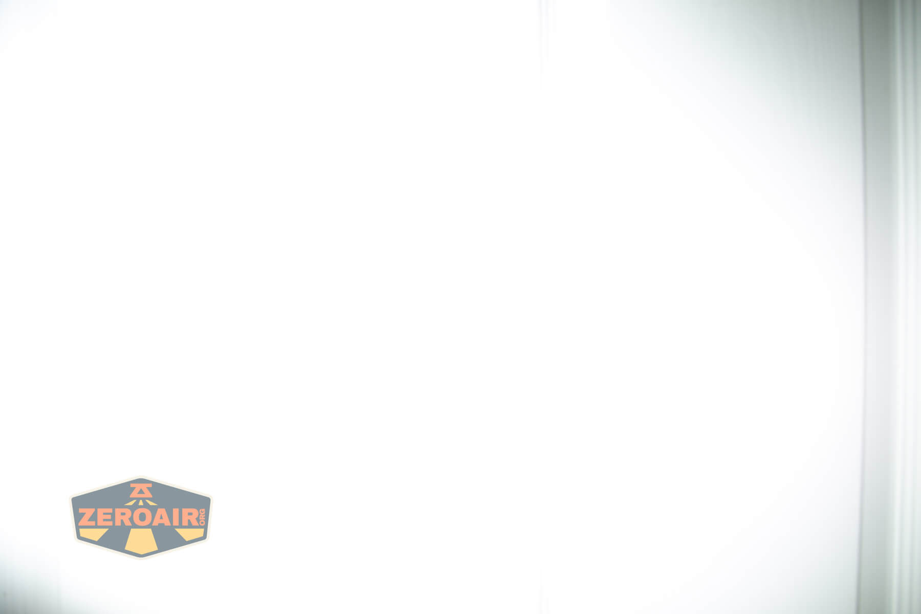 A mostly white, overexposed image with faint vertical lines on the right edge and a small ZEROAIR logo in the bottom left corner.