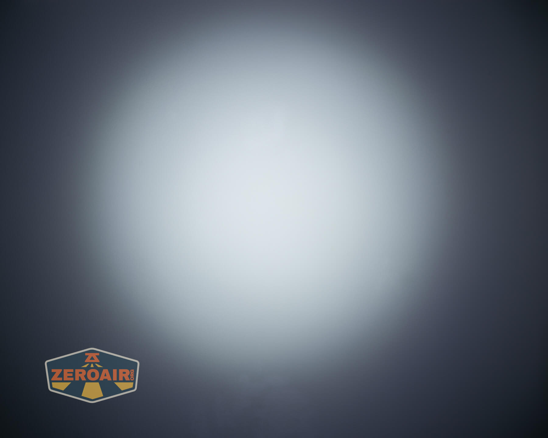 A focused white light beam forms a bright circular spot in the center of a dark background. The ZeroAir logo appears in the bottom left corner.