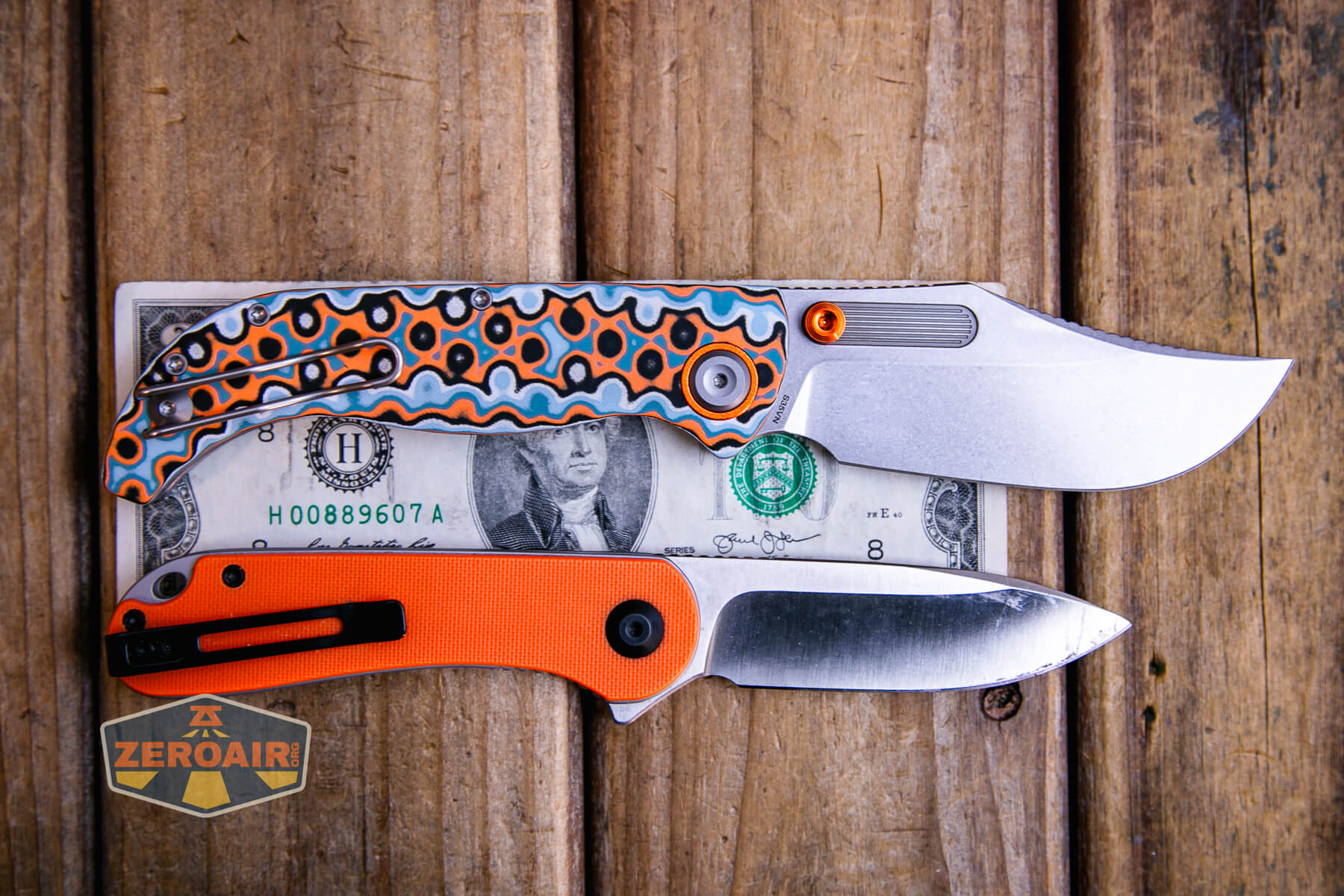 Vosteed Naga S35VN knife on a two dollar bill compared to Civivi Elementum in orange