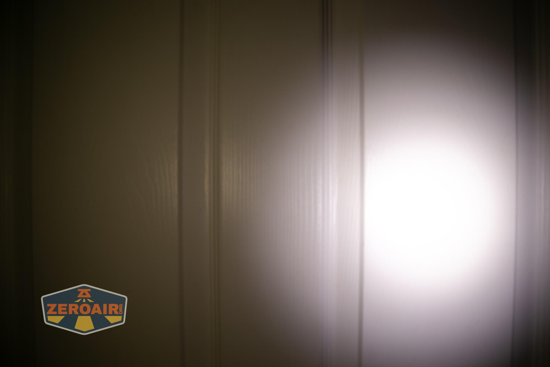 Wuben H4 Multi-function headlight beamshots on door compared to nichia 219b