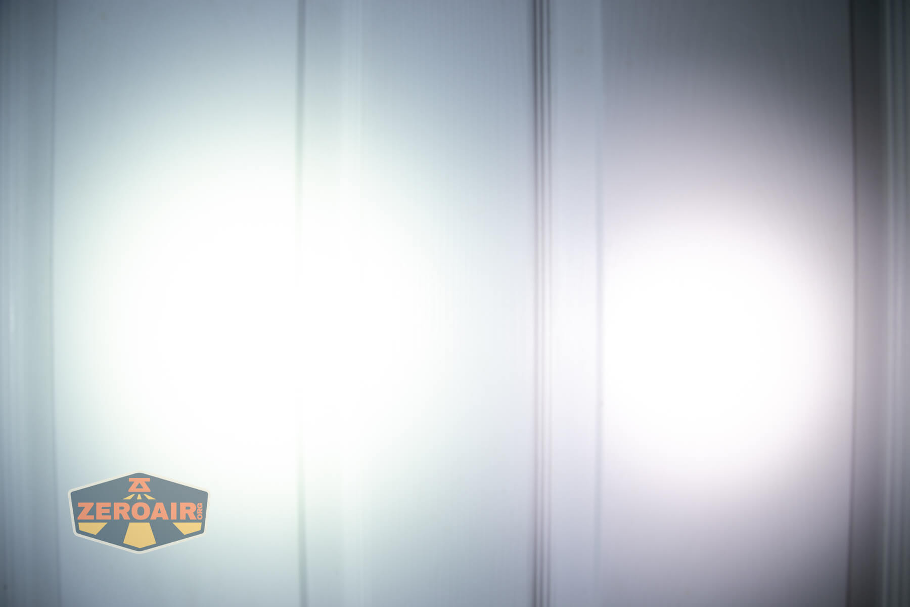 Wuben H4 Multi-function headlight beamshots on door compared to nichia 219b