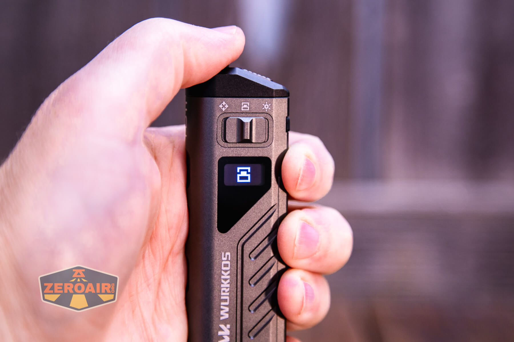 A hand holds a Wurkkos flashlight with a digital display showing the number 2. Several symbols are visible above the display. The ZeroAir logo is in the bottom left corner.