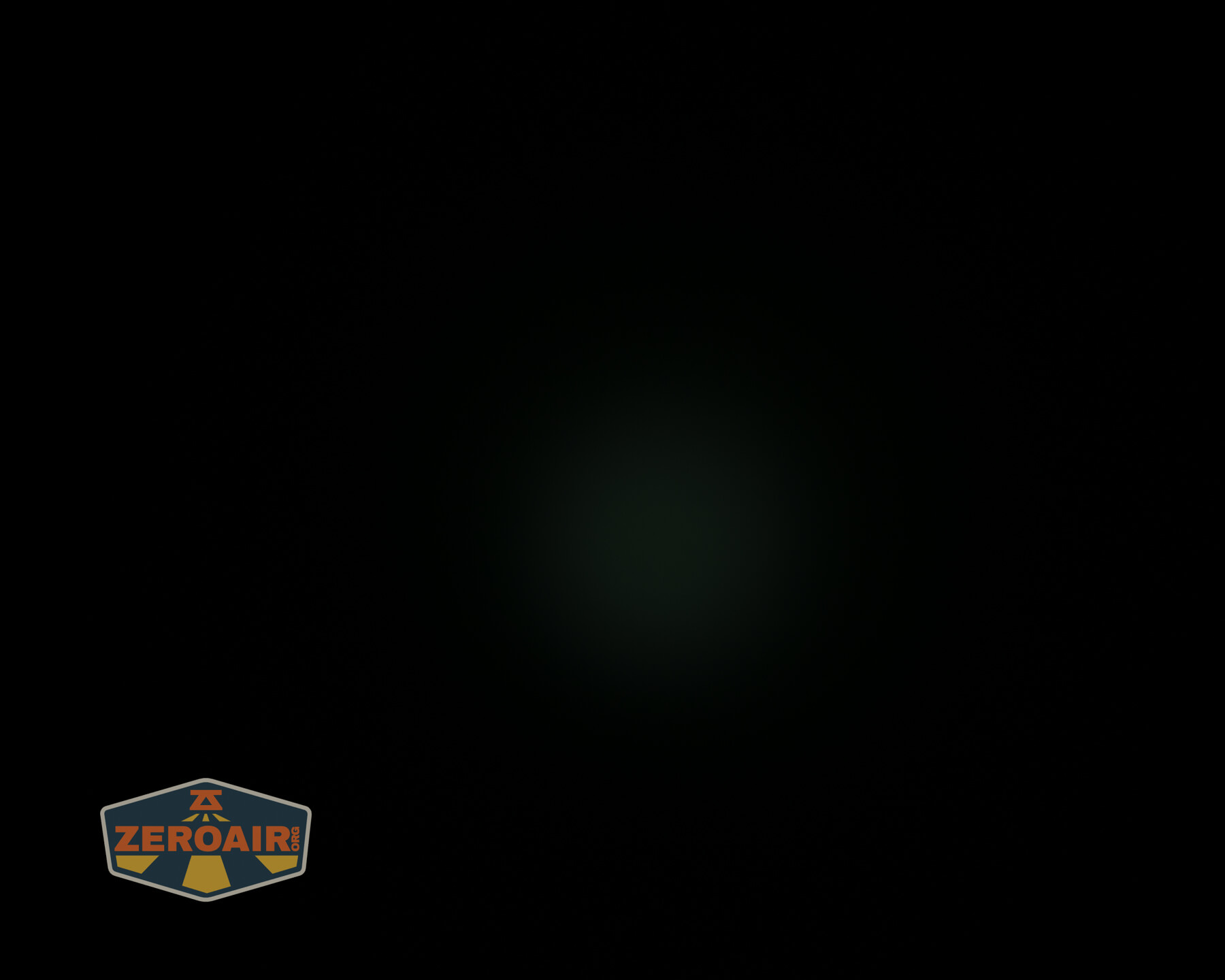 A mostly black image with a faint, dim circle of light in the center. In the bottom left corner, there is a shield-shaped logo with the text ZEROAIR.