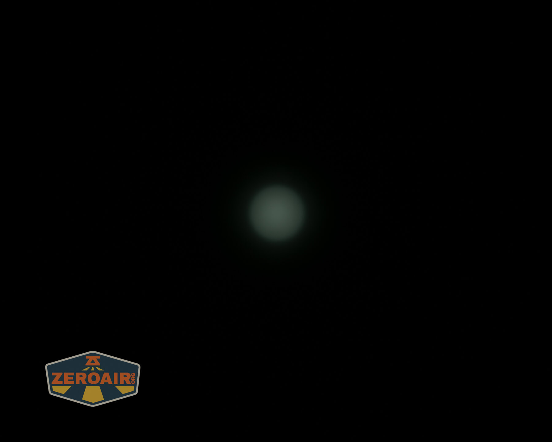 A dark background with a faint, circular greenish light in the center. In the bottom left corner, there is a ZeroAir logo with orange and yellow text and design.