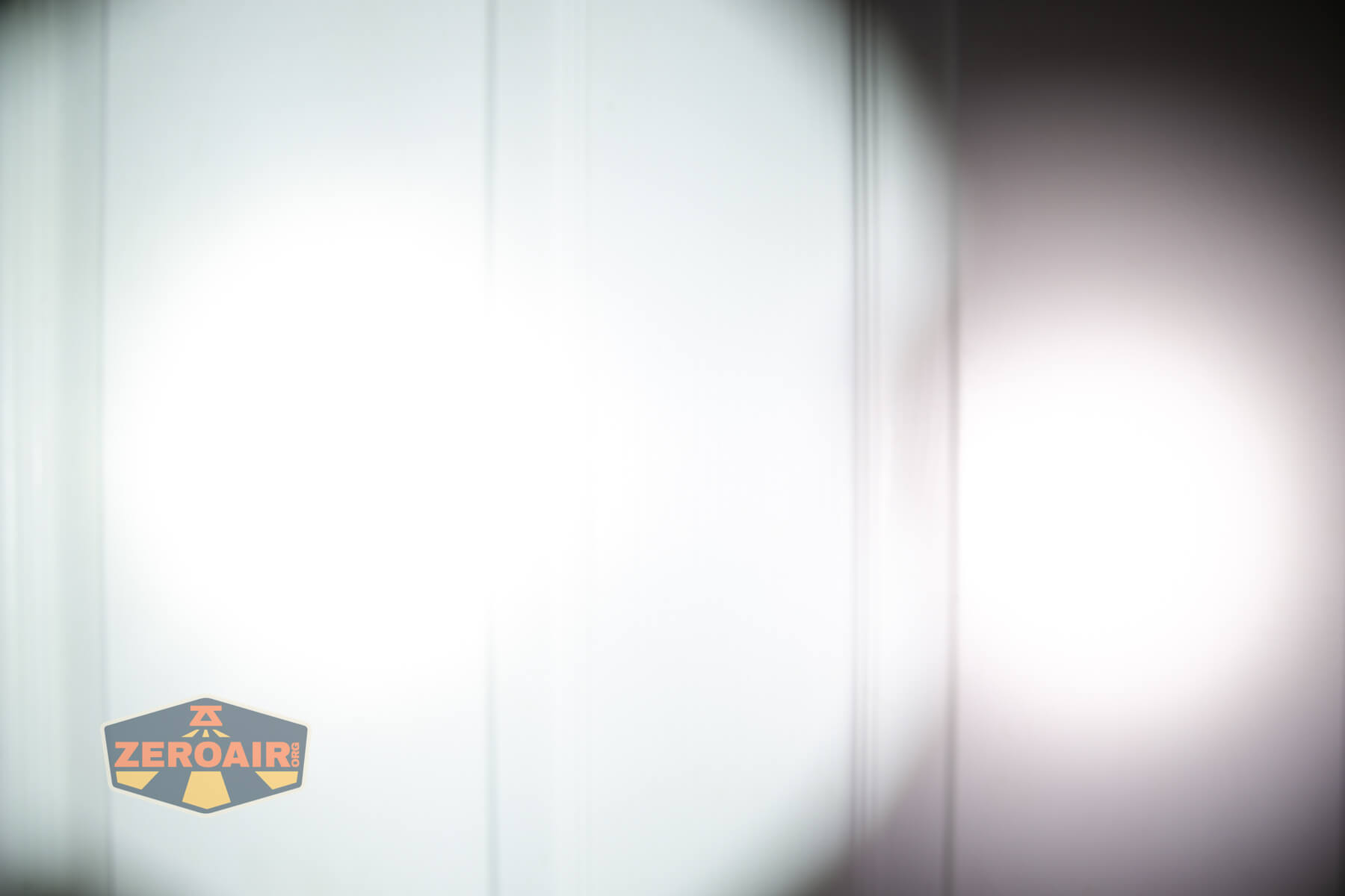 Nextorch Artorch compact EDC tactical flashlight beamshots on door (at 1') compared to nichia 219b 4500K