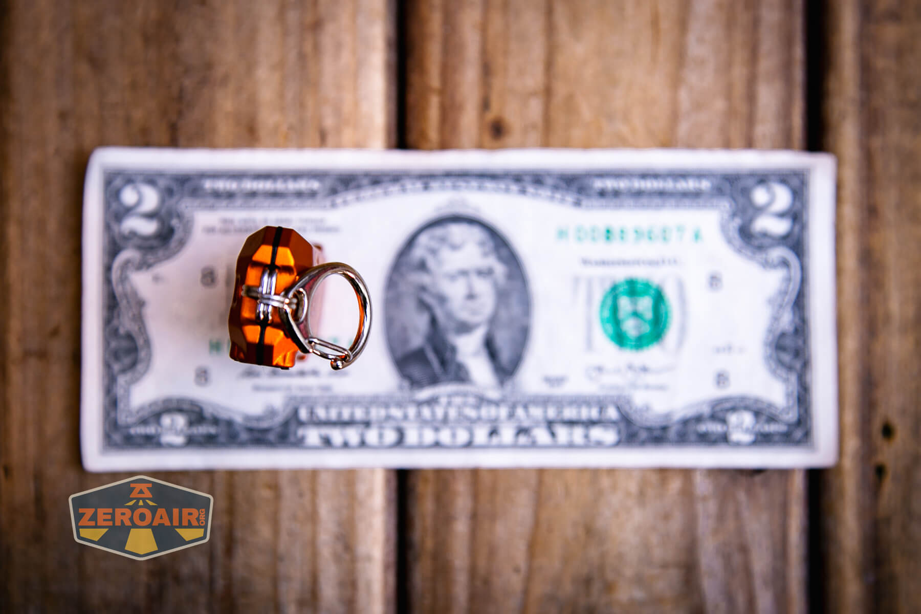 Nitecore TIP3 keychain flashlight showing all sides on a two dollar bill