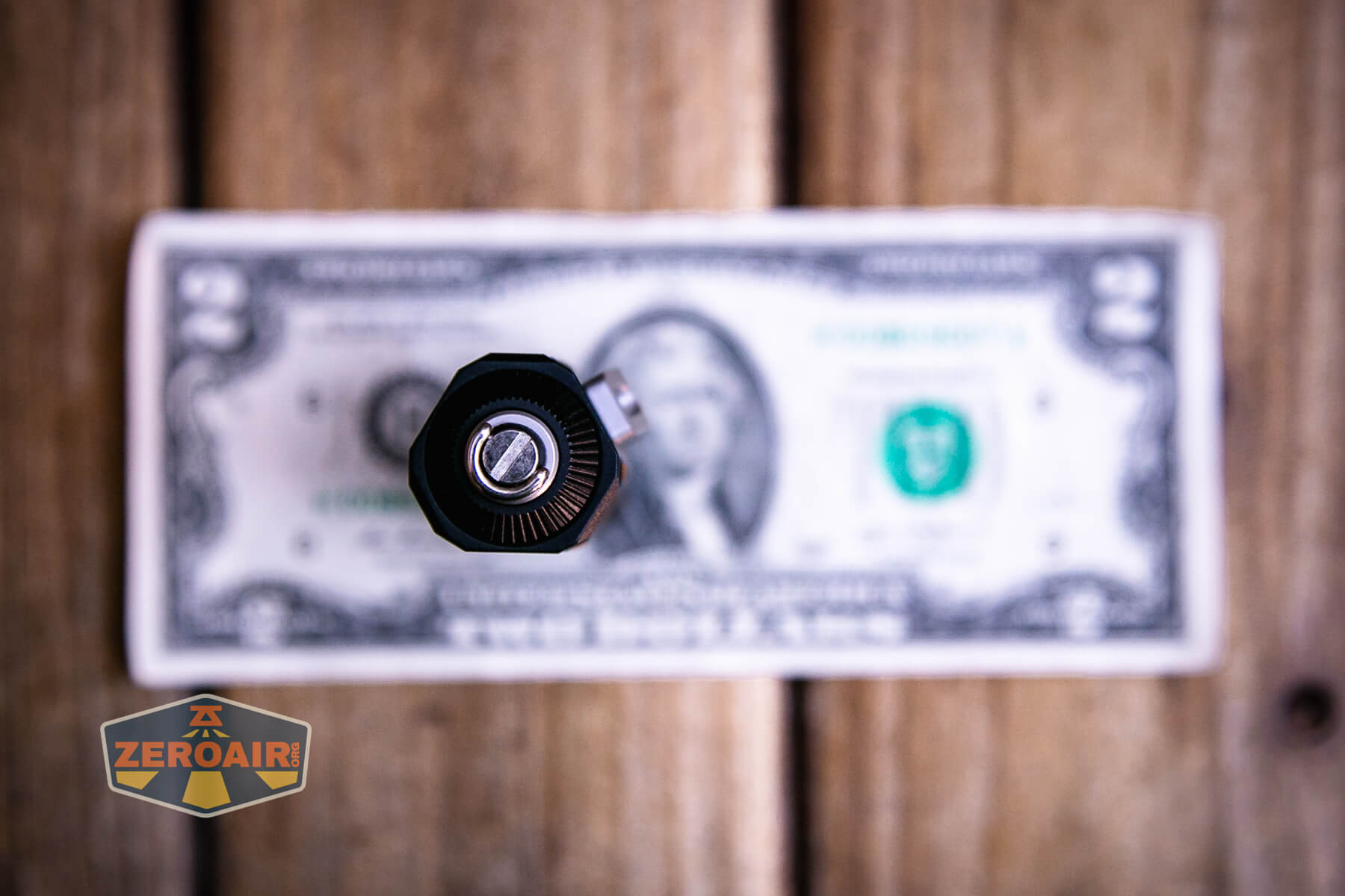 Wuben E Production Flashlight on two dollar bill