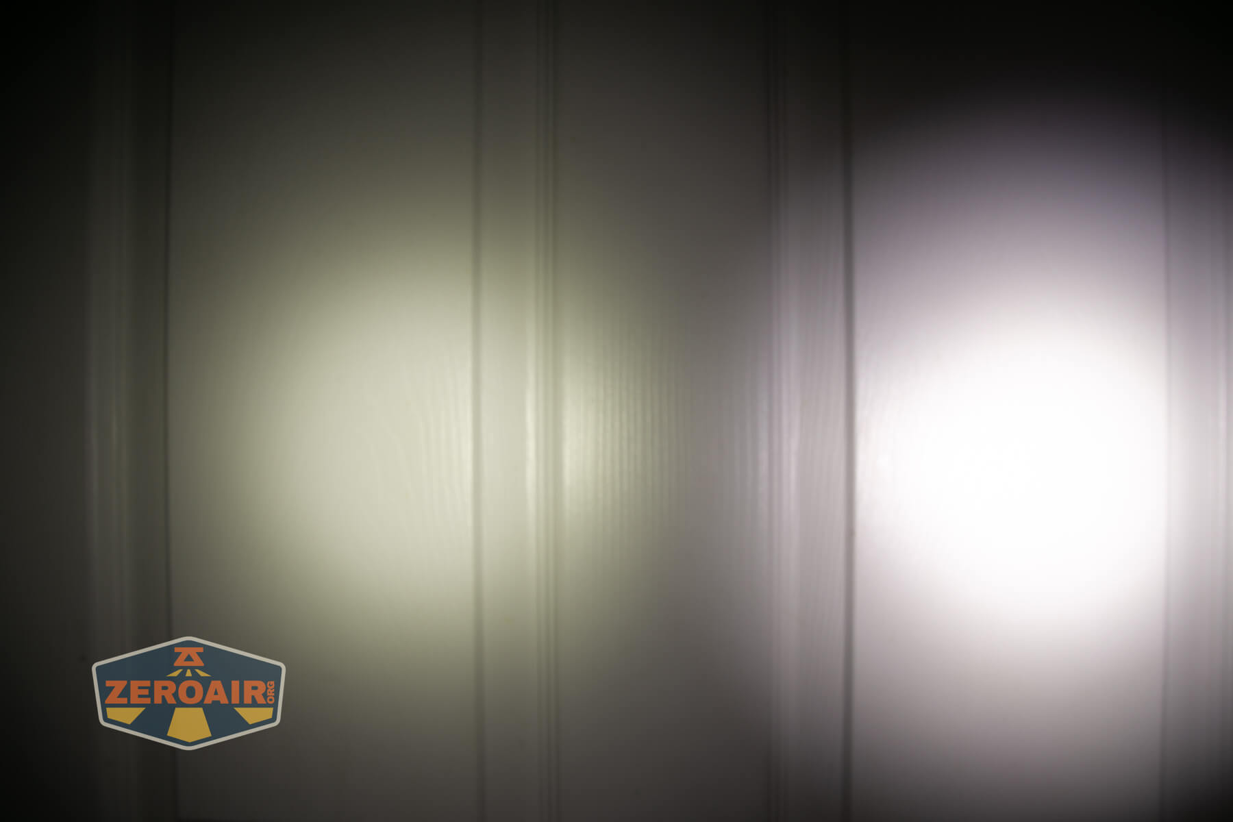 Wuben E Production flashlight beamshots on door compared to Nichia 219bA