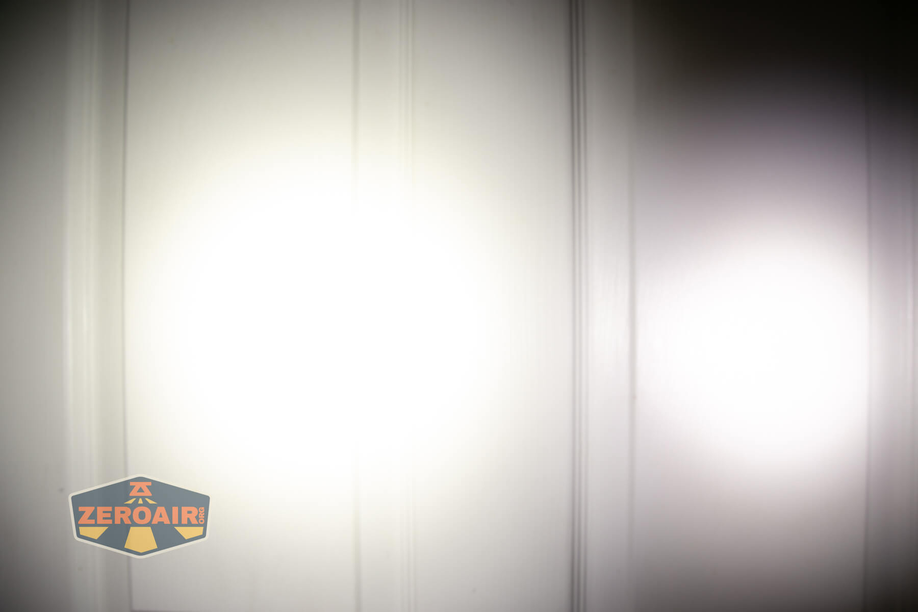 Wuben E Production flashlight beamshots on door compared to Nichia 219bA