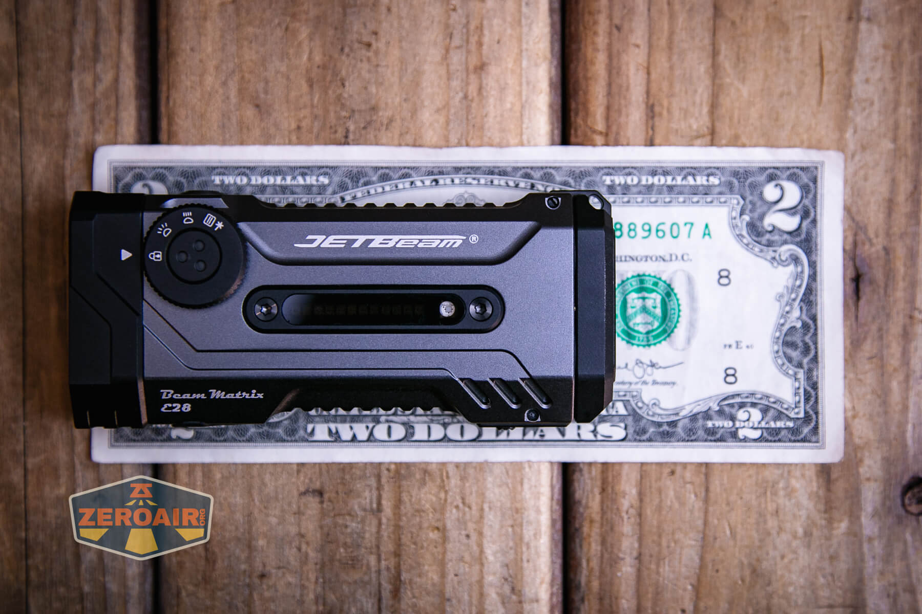 JETBeam E28 EDC Multi-mode Flat Tactical flashlight on a two dollar bill