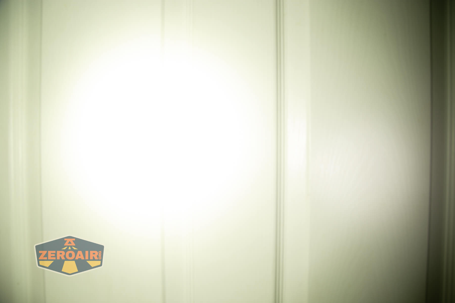 JETBeam E28 EDC Multi-mode Flat Tactical flashlight beamshots on door (at 1') compared to nichia 219b 4500K