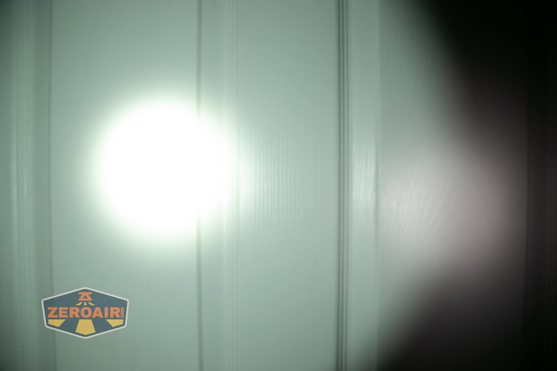 JETBeam E28 EDC Multi-mode Flat Tactical flashlight beamshots on door (at 1') compared to nichia 219b 4500K