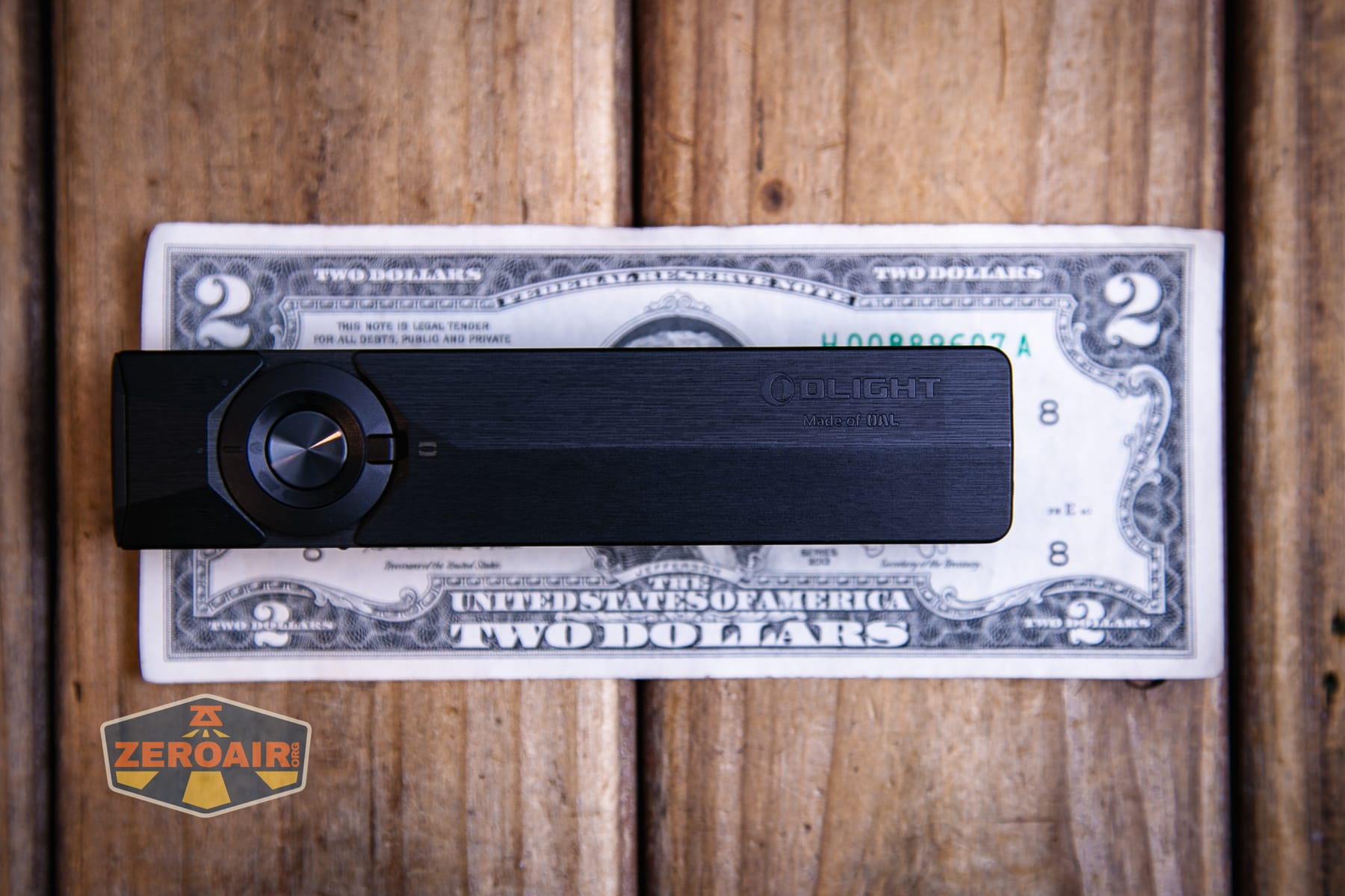 Olight ArkPro Ultra Onyx Black flashlight on a two dollar bill