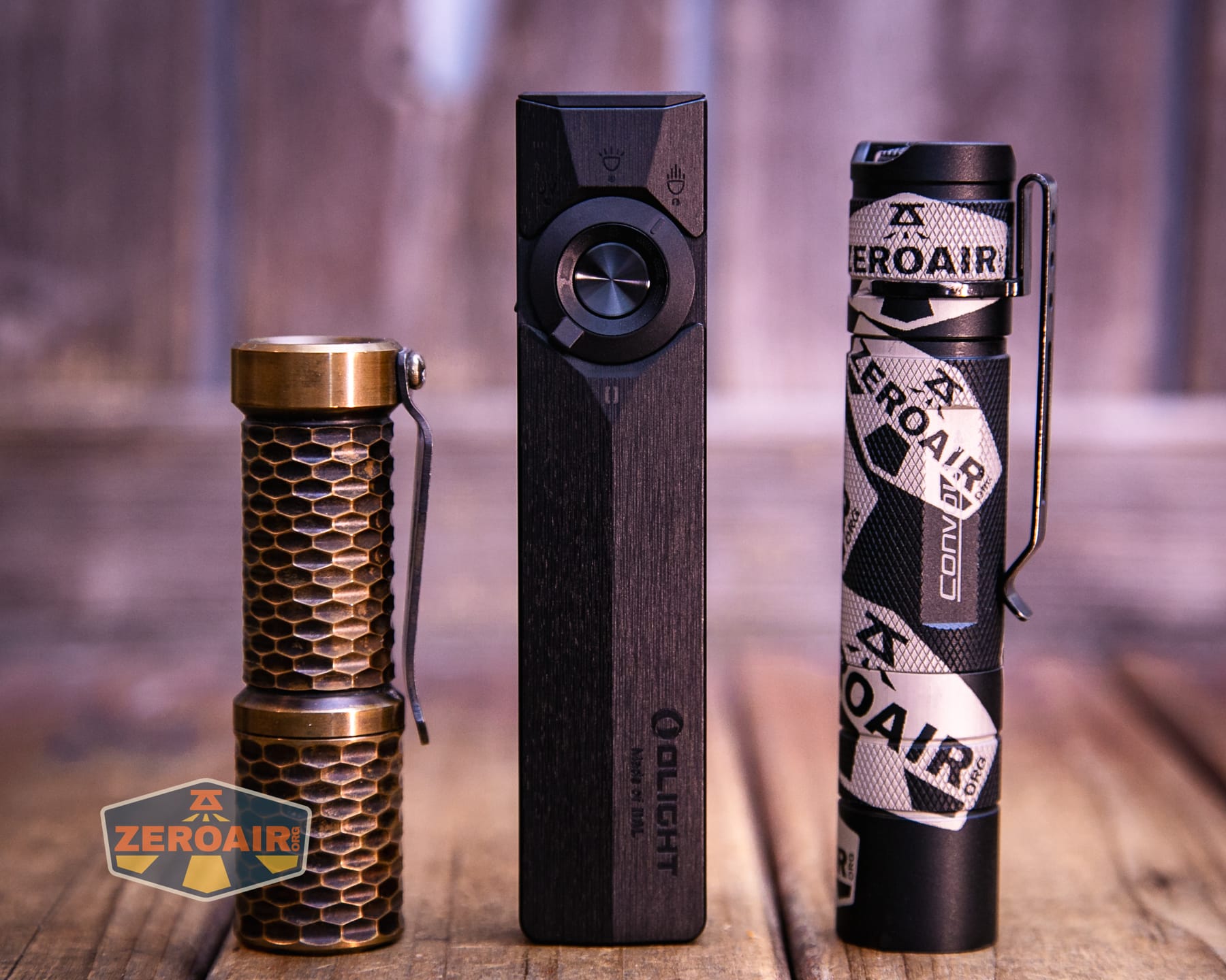 Olight ArkPro Ultra Onyx Black flashlight with two standard sized flashlights