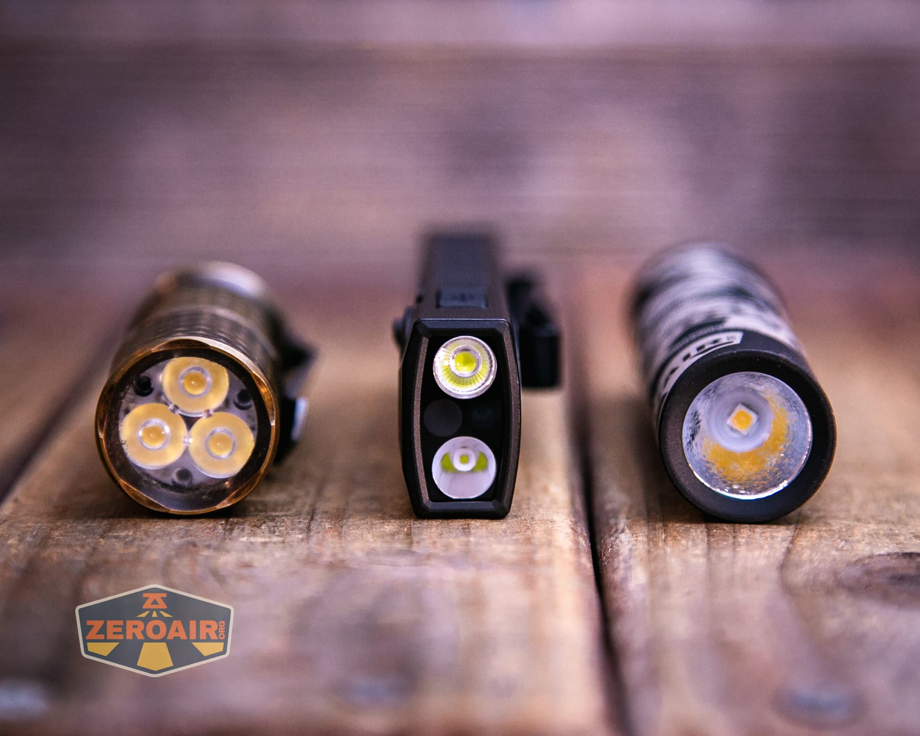 Olight ArkPro Ultra Onyx Black flashlight with two standard sized flashlights