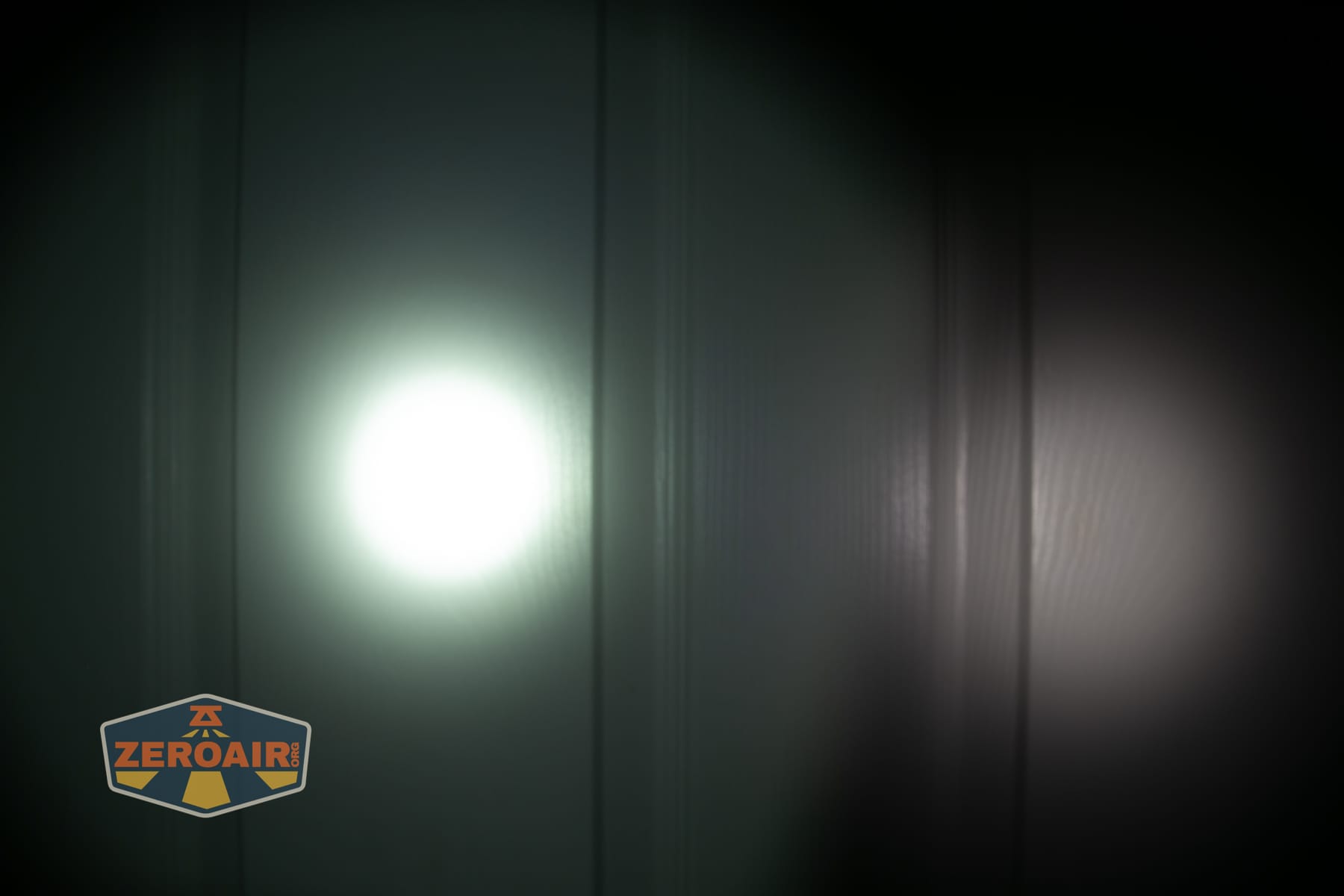 Olight ArkPro Ultra Onyx Black flashlight beamshots on door (at 1') compared to nichia 219b 4500K