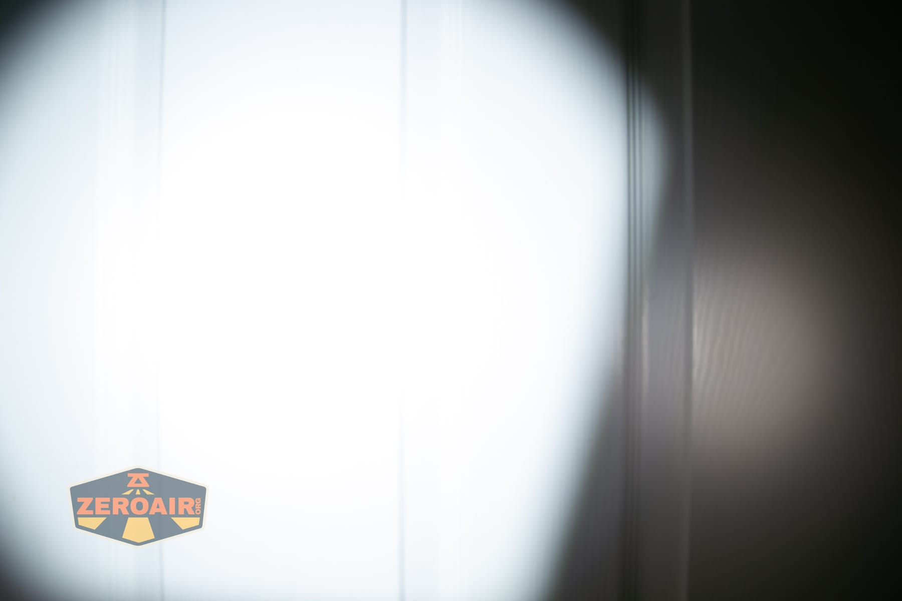 Olight ArkPro Ultra Onyx Black flashlight beamshots on door (at 1') compared to nichia 219b 4500K