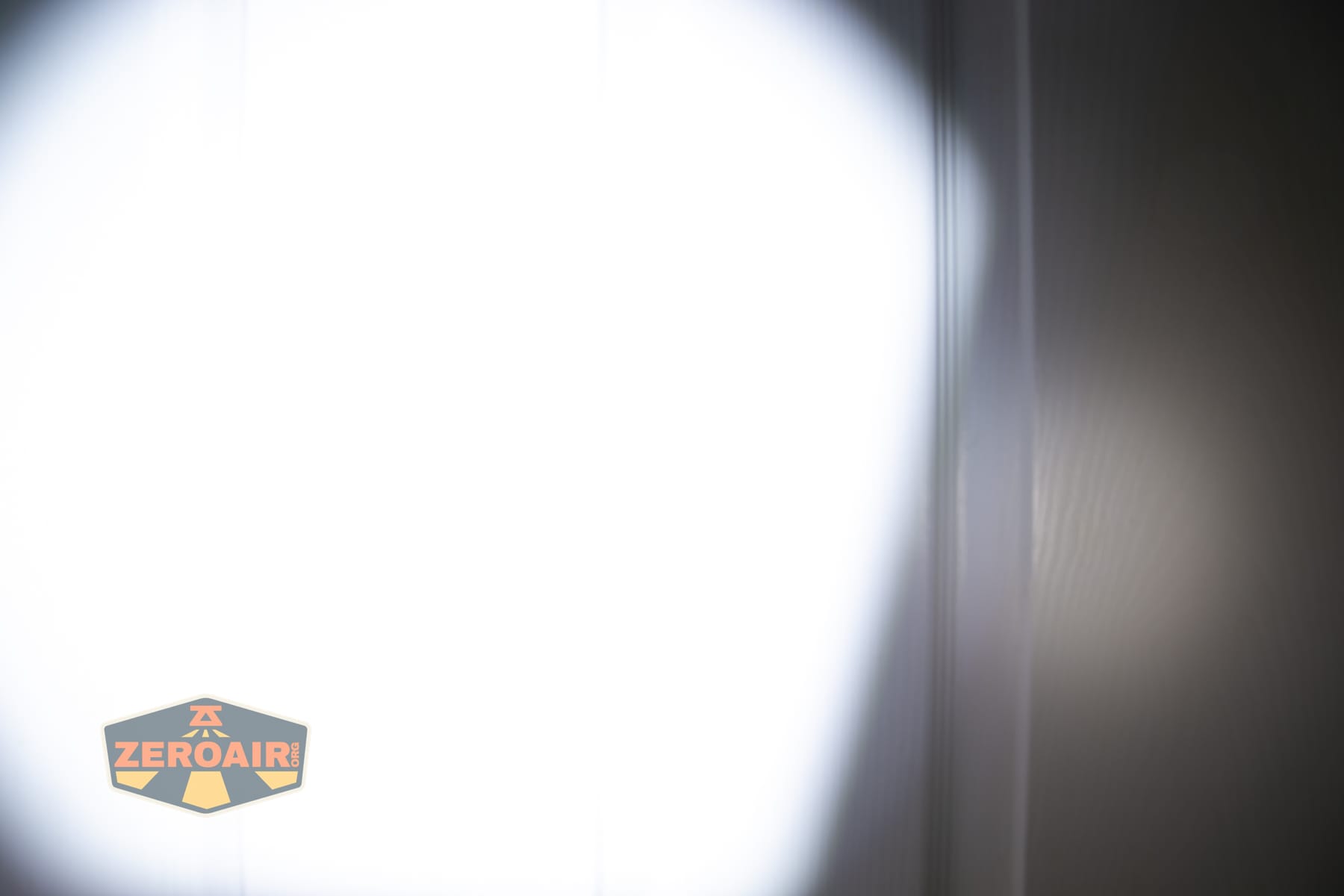 Olight ArkPro Ultra Onyx Black flashlight beamshots on door (at 1') compared to nichia 219b 4500K
