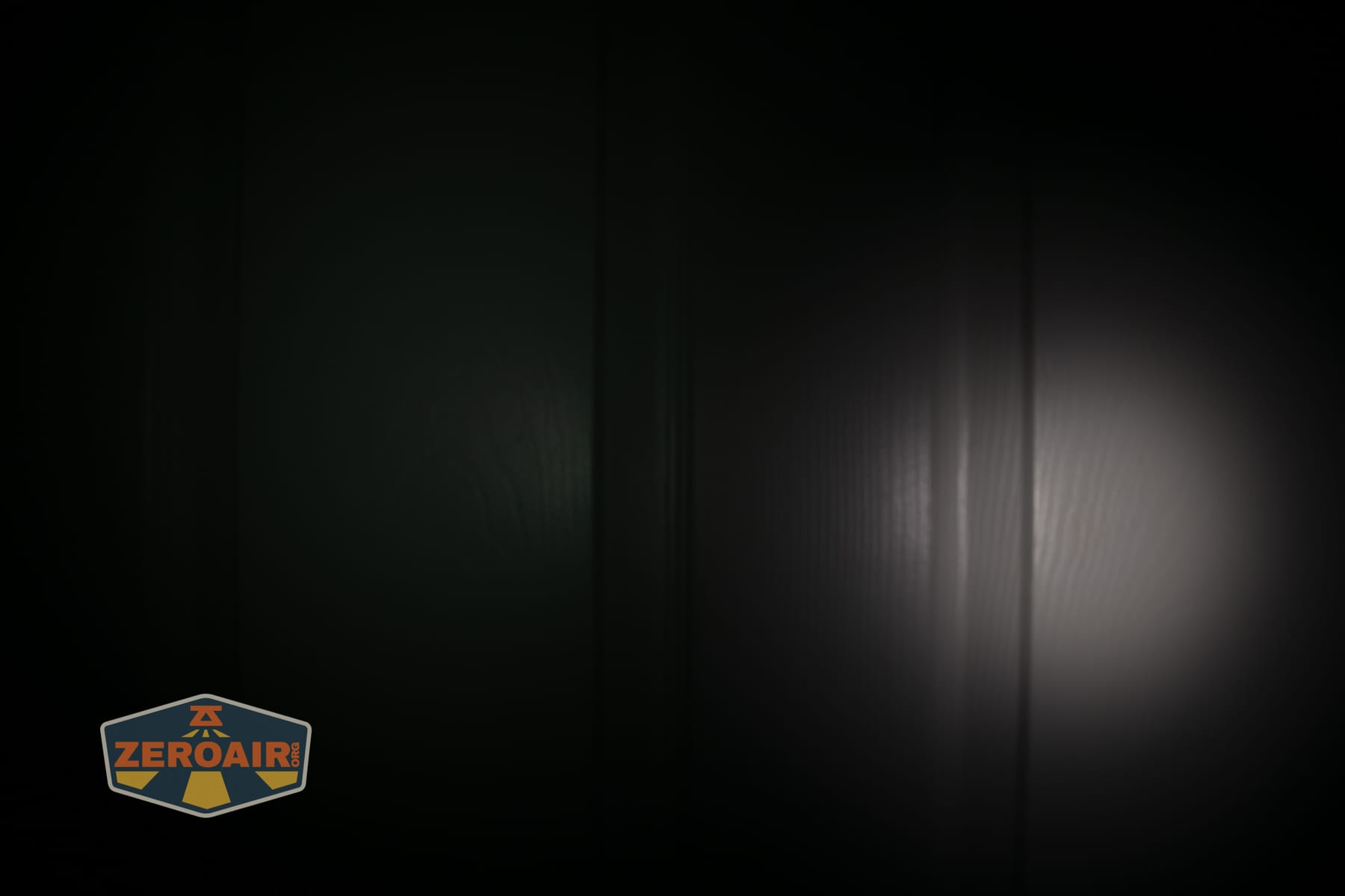 Olight ArkPro Ultra Onyx Black flashlight beamshots on door (at 1') compared to nichia 219b 4500K