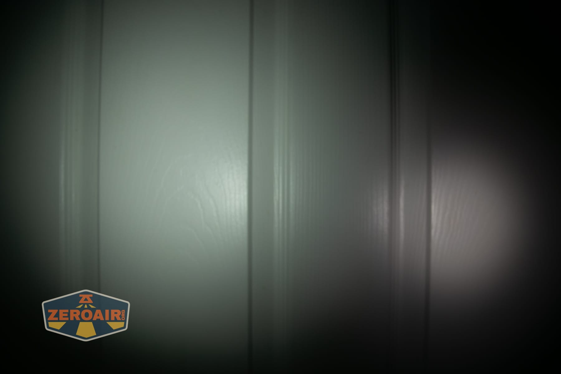 Olight ArkPro Ultra Onyx Black flashlight beamshots on door (at 1') compared to nichia 219b 4500K
