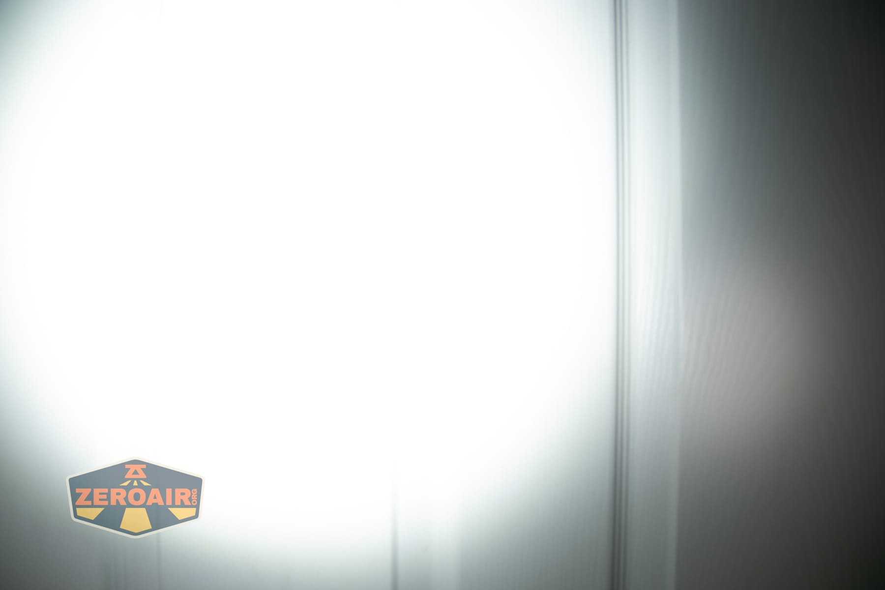 Olight ArkPro Ultra Onyx Black flashlight beamshots on door (at 1') compared to nichia 219b 4500K