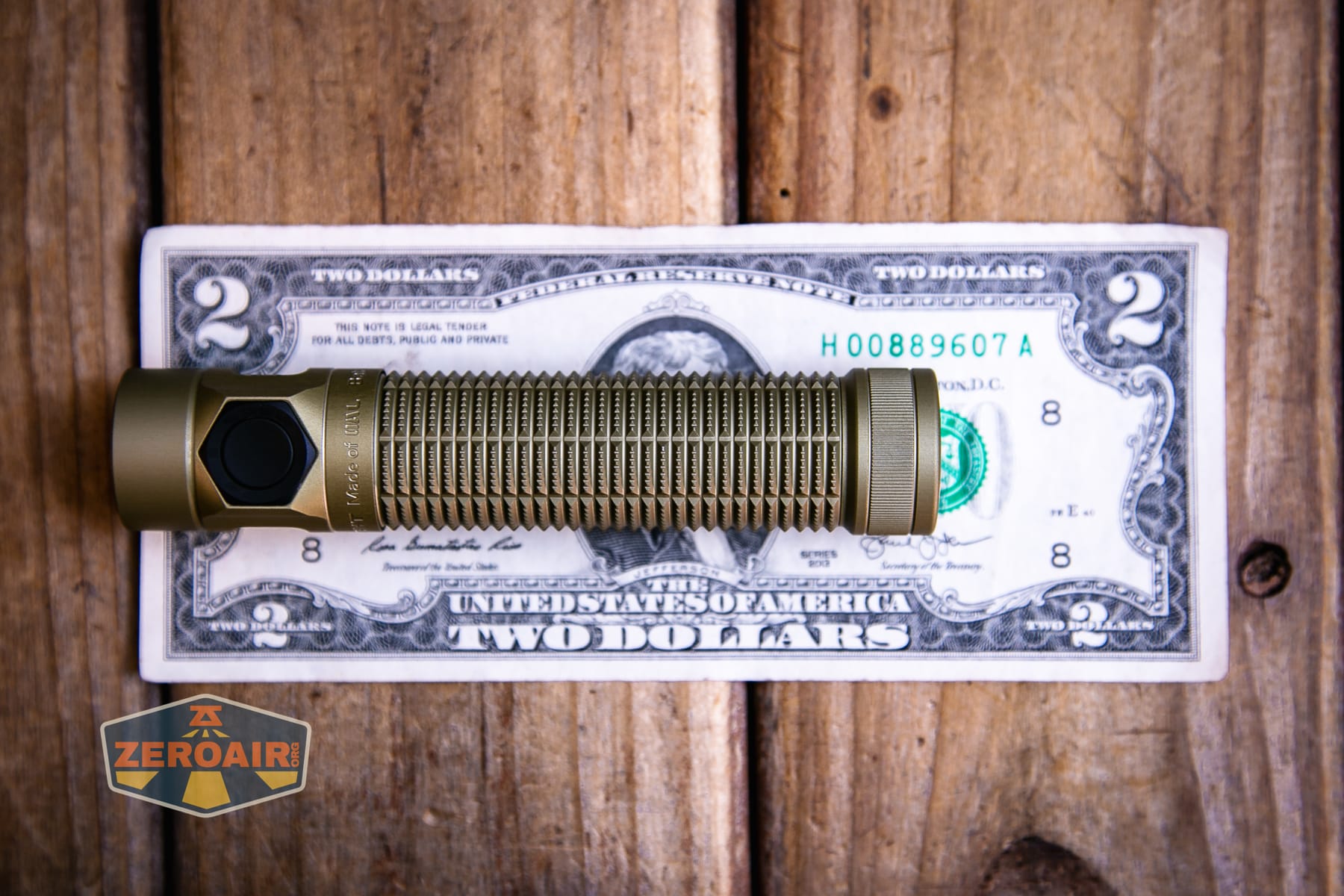 Olight Baton Ultra OAL flashlight on a two dollar bill