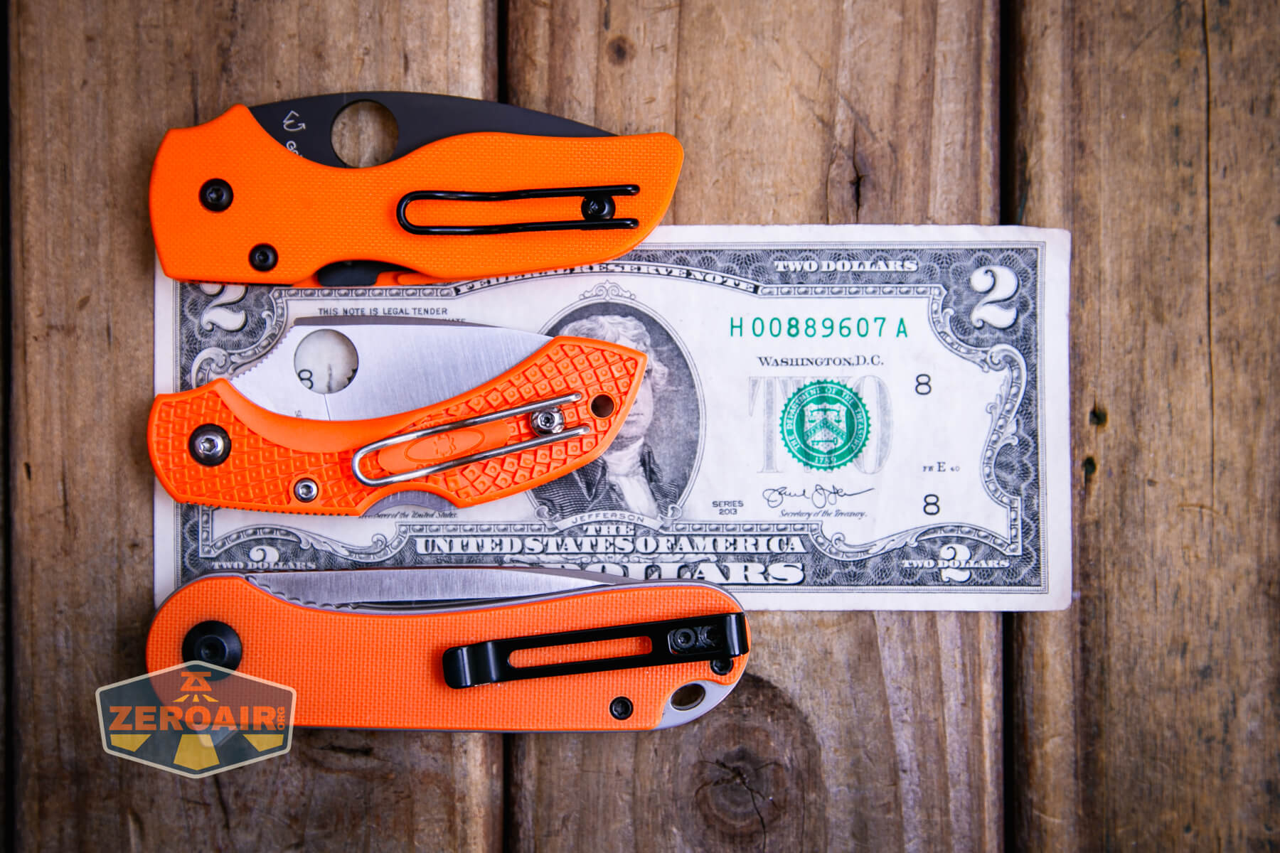 Spyderco Dragonfly 2 Lightweight knife on a two dollar bill compared to Civivi Elementum in orange