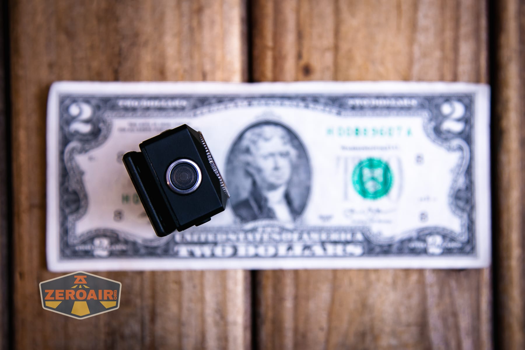 Trustfire Mini C Multifunctional clip-on flashlight on a two dollar bill
