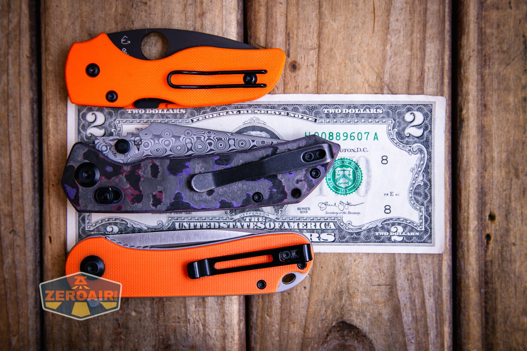 Kansept Fenrir Fatcarbon knife on a two dollar bill compared to Civivi Elementum in orange