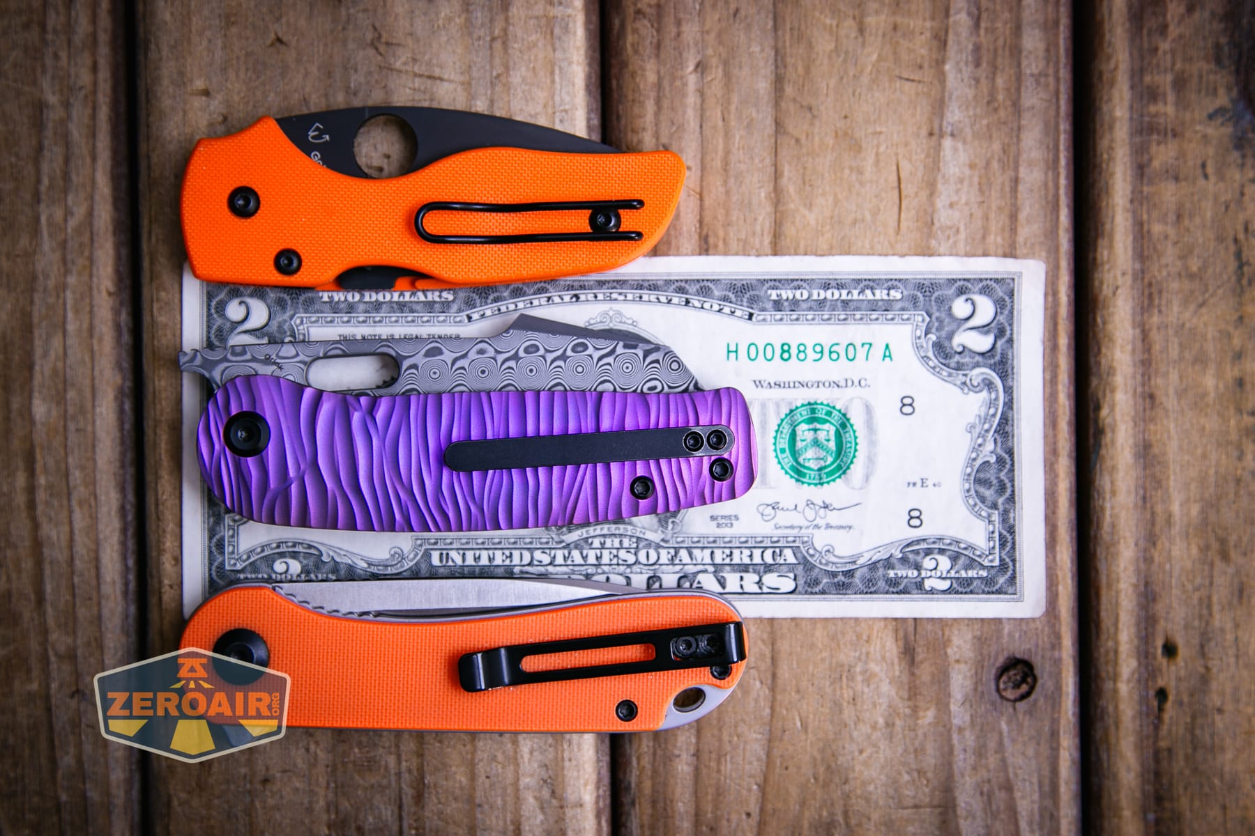 Kansept Orlok knife on a two dollar bill compared to Civivi Elementum in orange