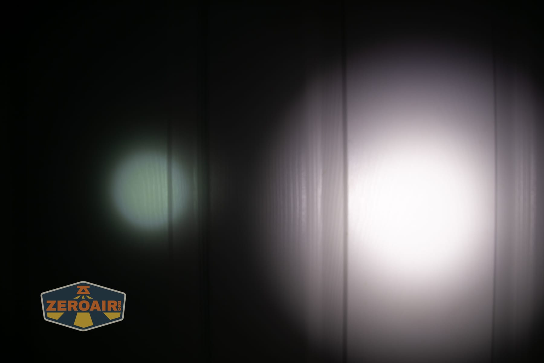 Olight Arkpro Stars and Stripes flat flashlight beamshots on door compared to Nichia 219b