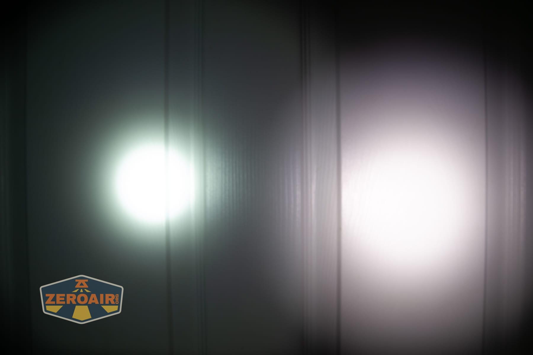 Olight Arkpro Stars and Stripes flat flashlight beamshots on door compared to Nichia 219b