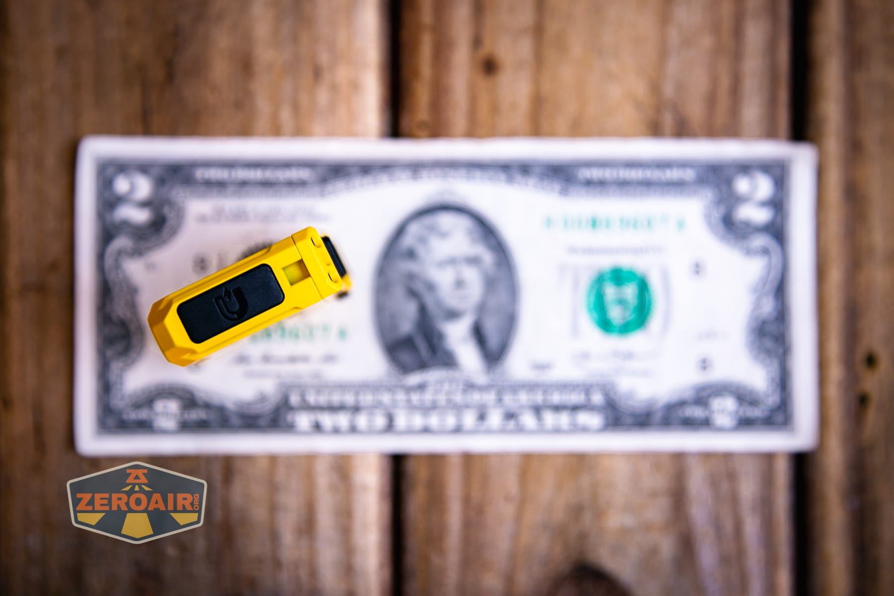Wuben G5 Yellow EDC Keychain flashlight on a two dollar bill