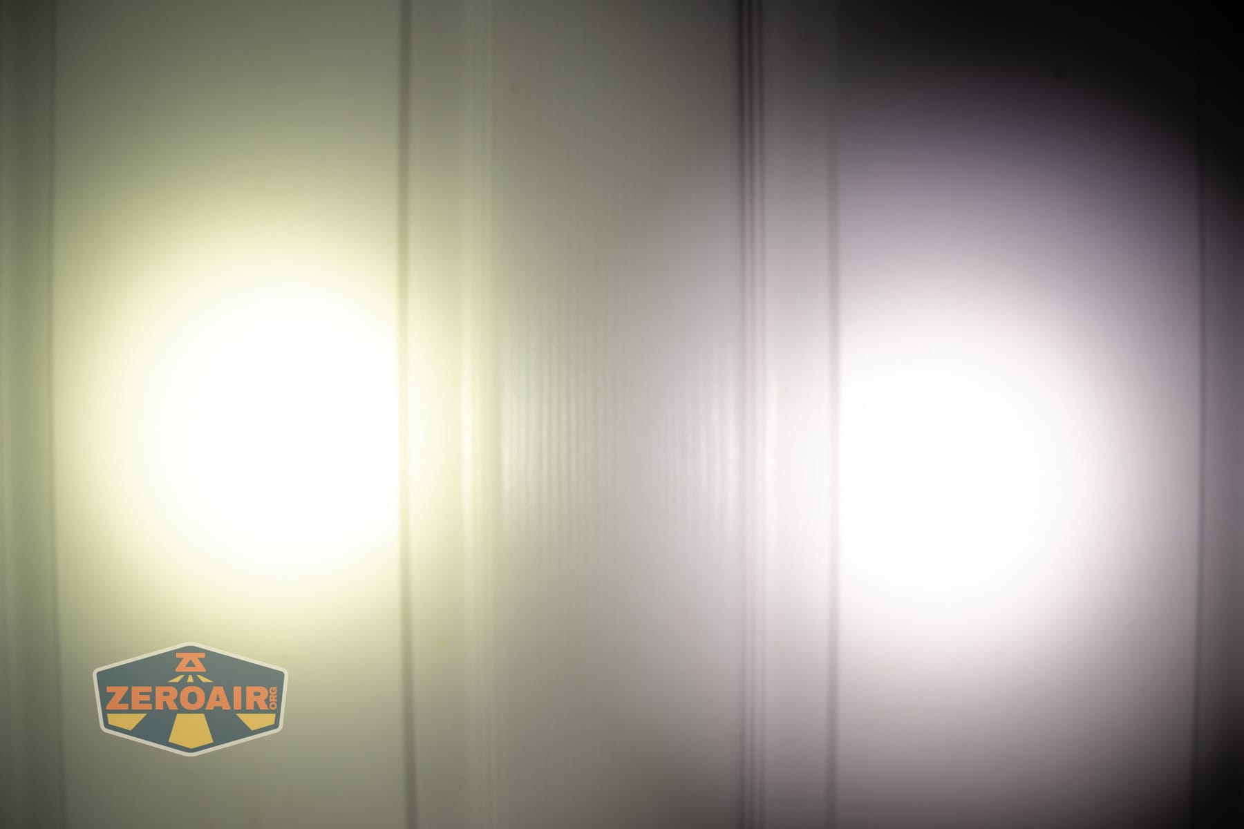 Wuben X5 3-in-1 compact EDC flashlight beamshots on door (at 1') compared to nichia 219b 4500K