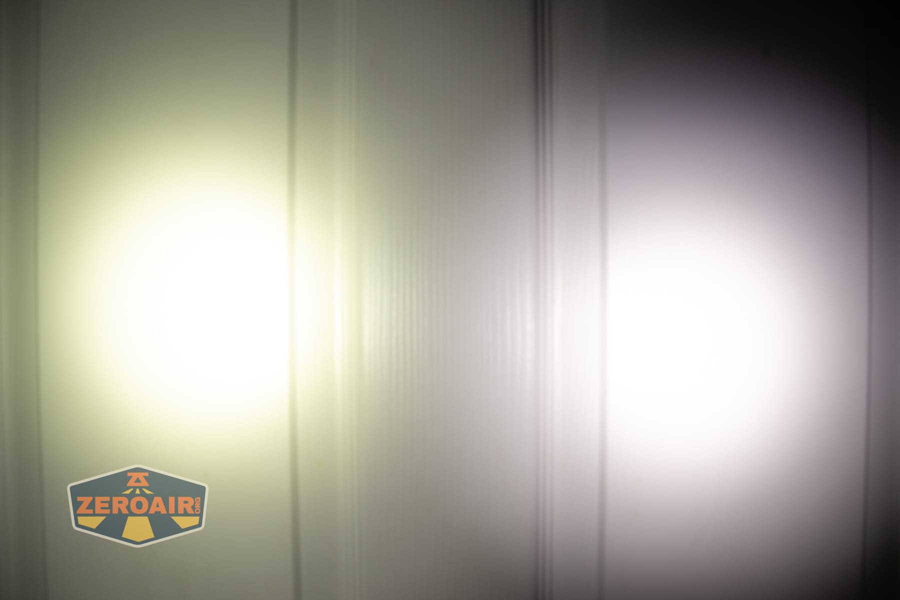 Wuben X5 3-in-1 compact EDC flashlight beamshots on door (at 1') compared to nichia 219b 4500K