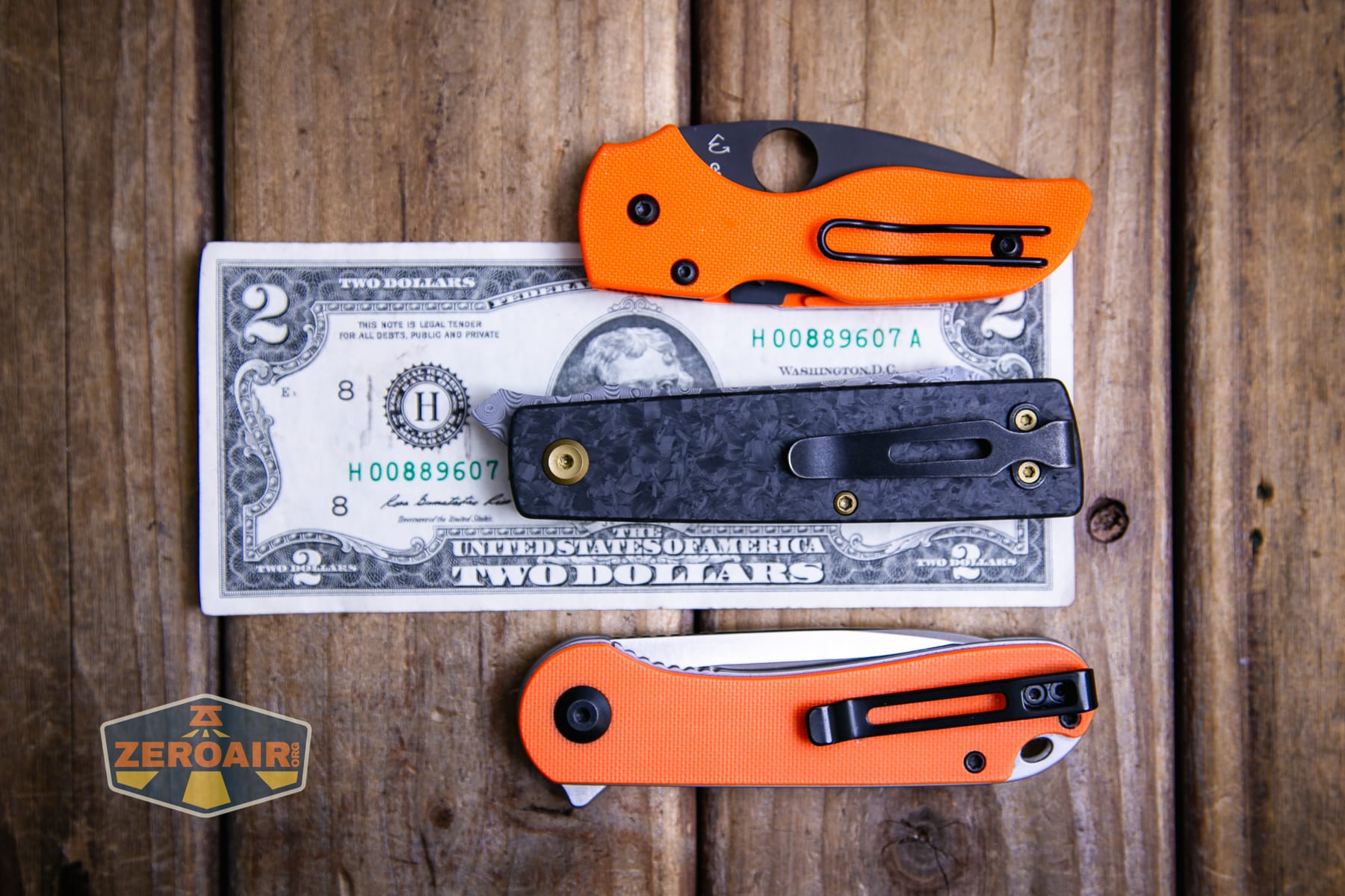 Kansept Higonokami liner lock knife on a two dollar bill compared to Civivi Elementum in orange