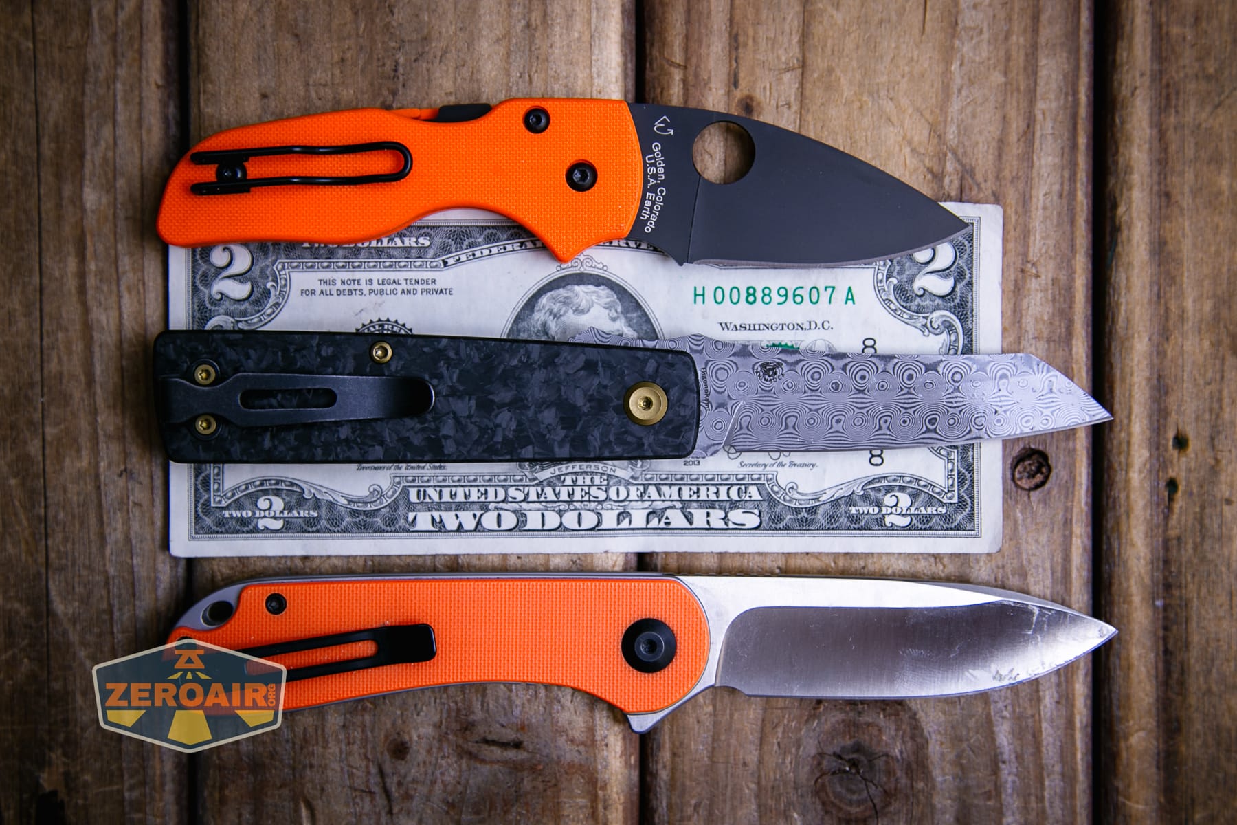 Kansept Higonokami liner lock knife on a two dollar bill compared to Civivi Elementum in orange