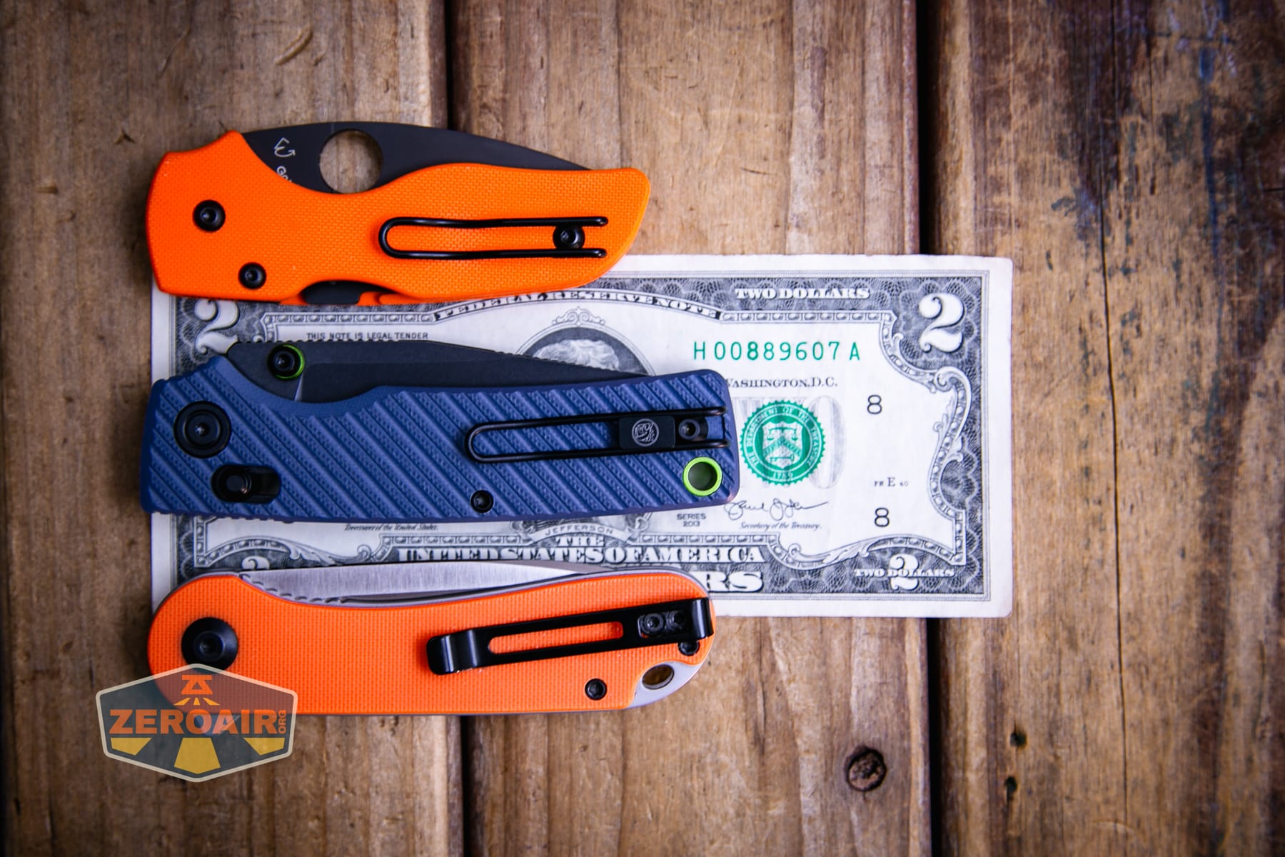 Vosteed Porcupine ModSwap Crossbar lock knife on a two dollar bill compared to Civivi Elementum in orange