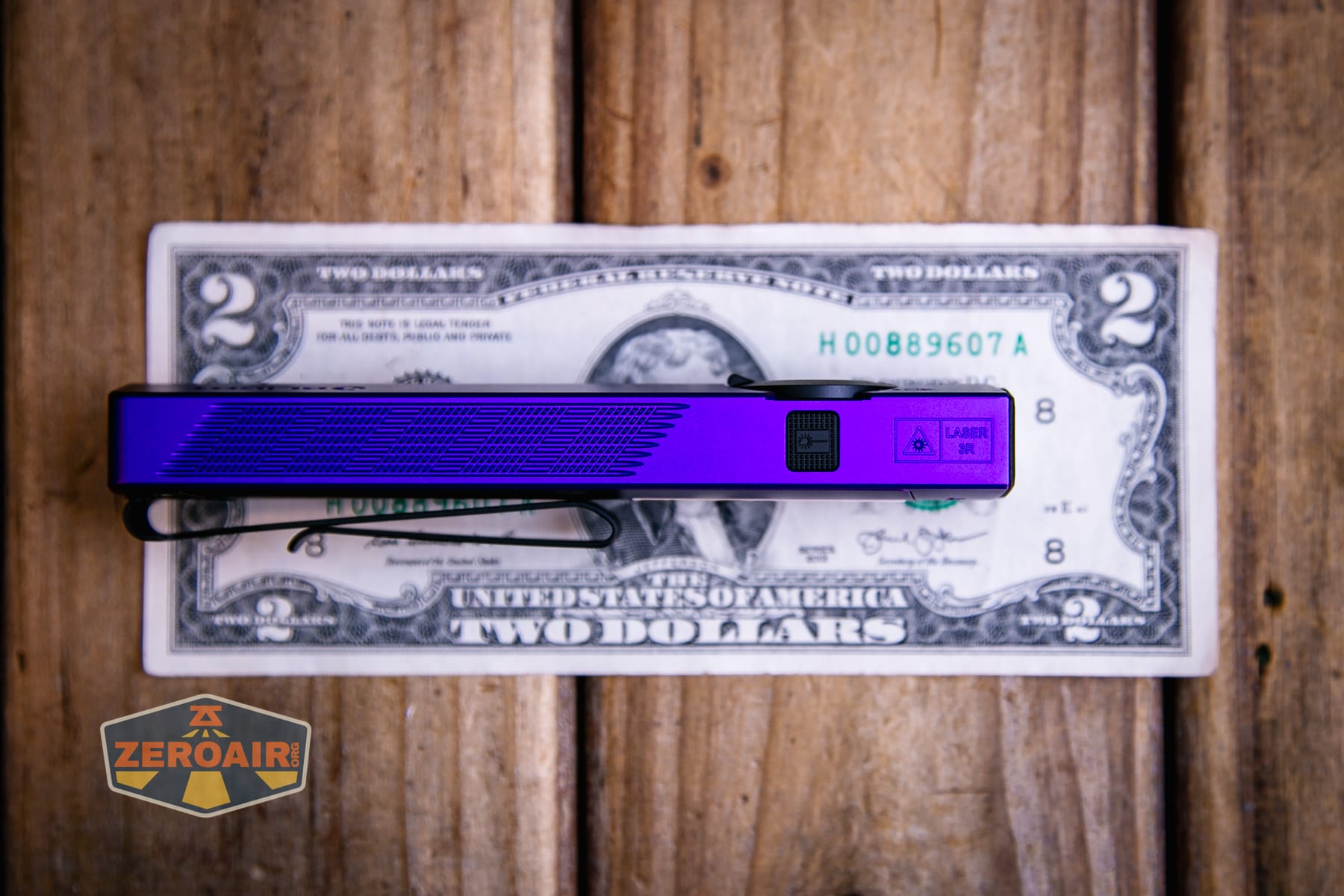Olight ArkPro Nebula Violet Flat flashlight on a two dollar bill