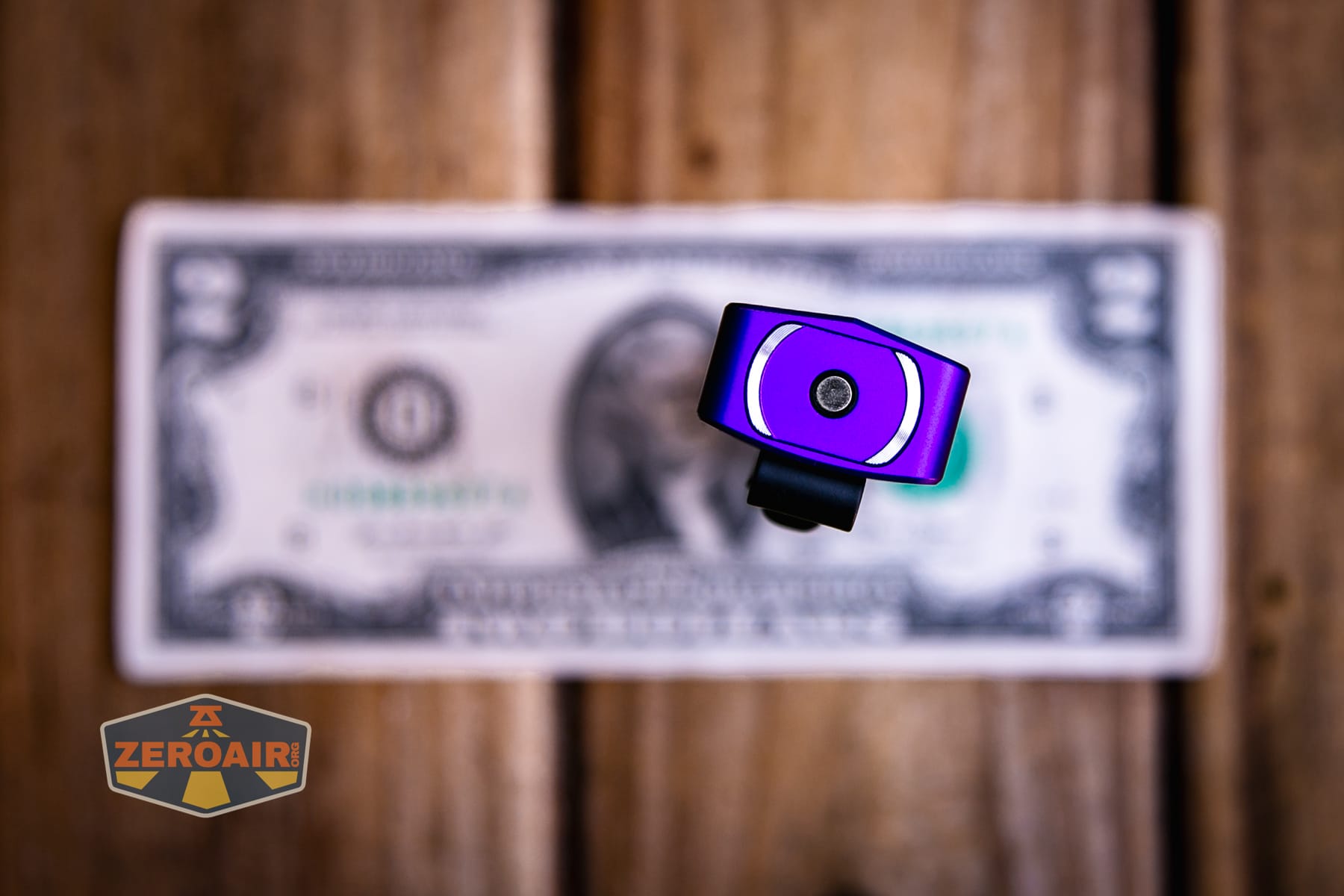 Olight ArkPro Nebula Violet Flat flashlight on a two dollar bill