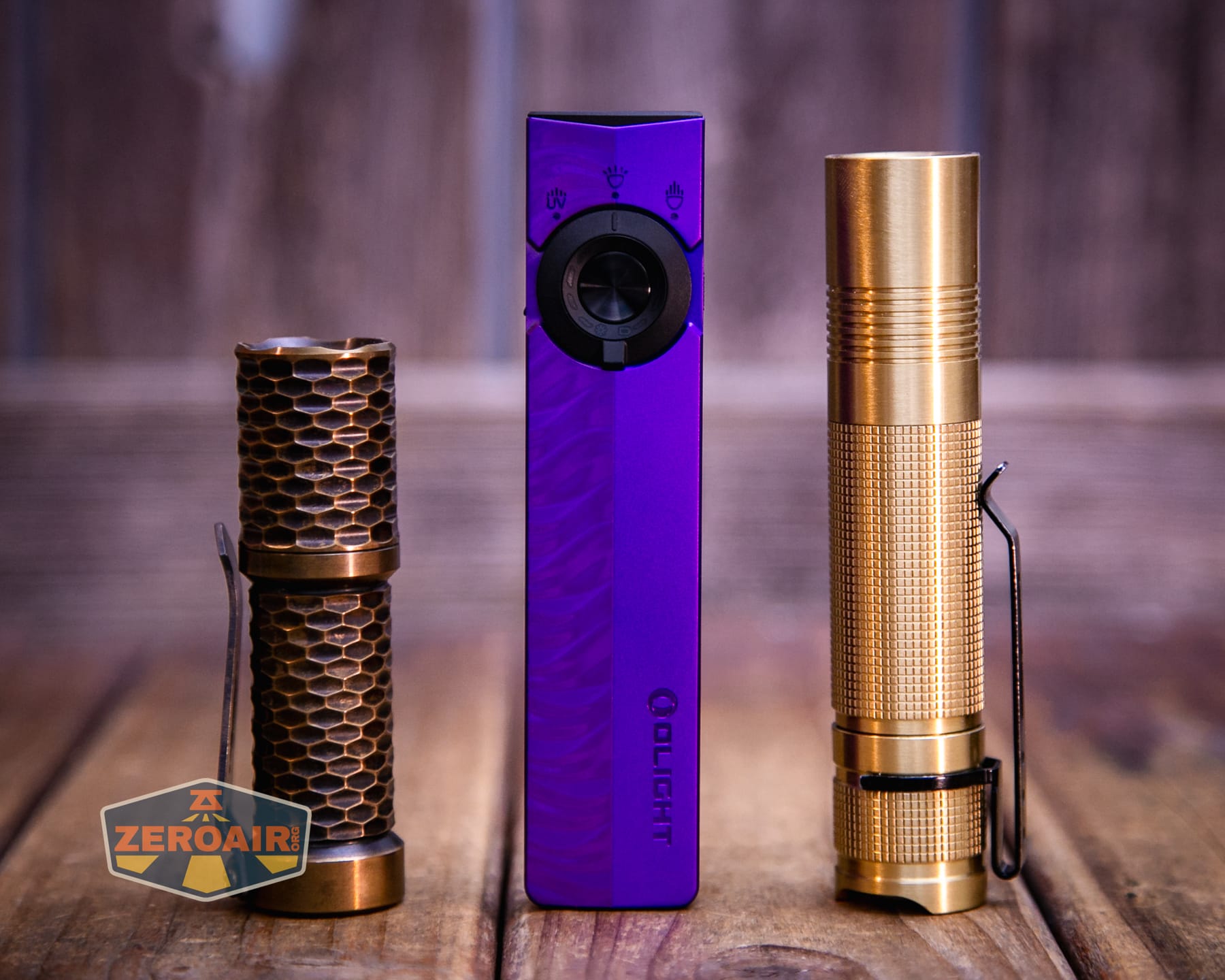 Olight ArkPro Nebula Violet Flat flashlight with two standard sized flashlights