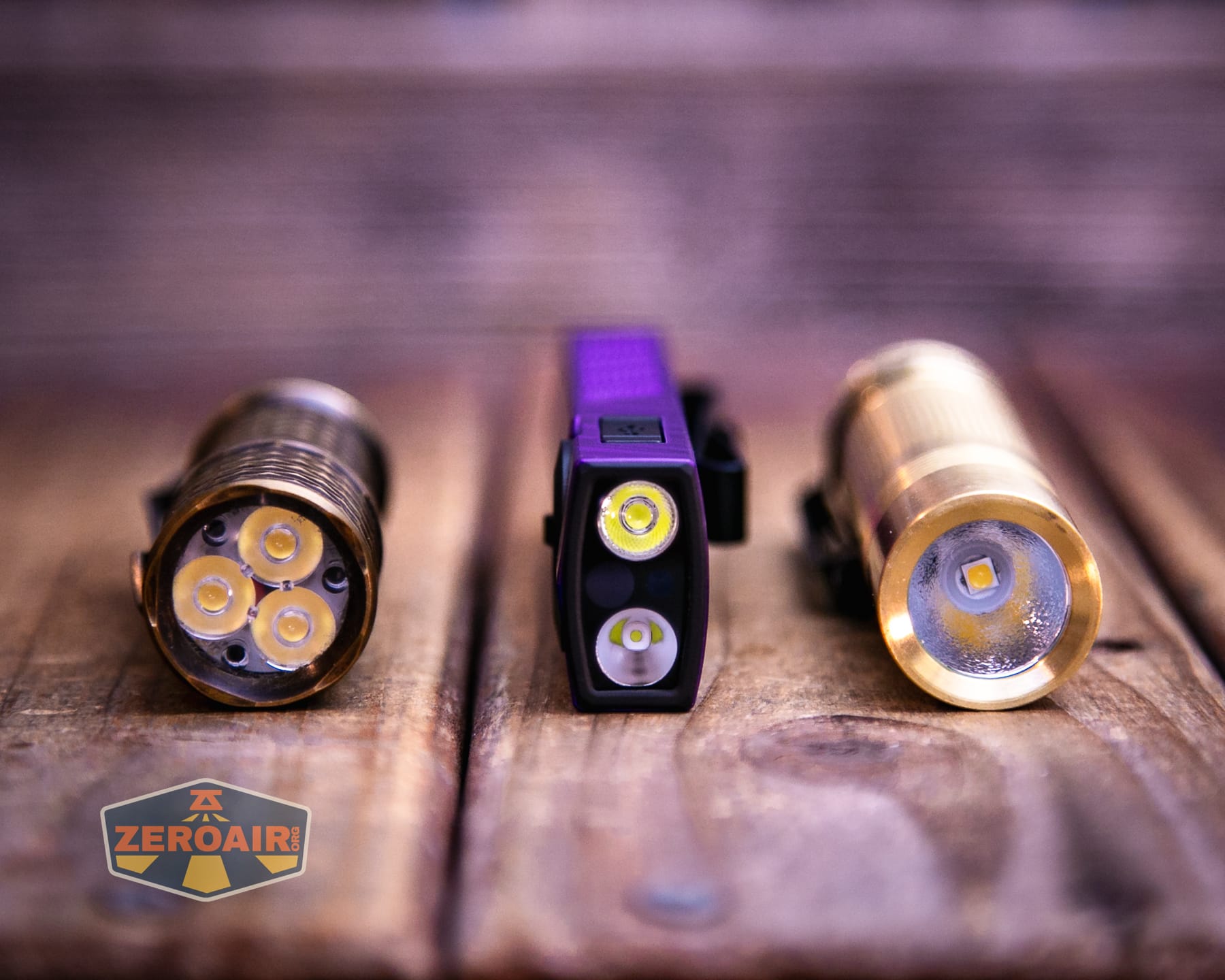 Olight ArkPro Nebula Violet Flat flashlight with two standard sized flashlights