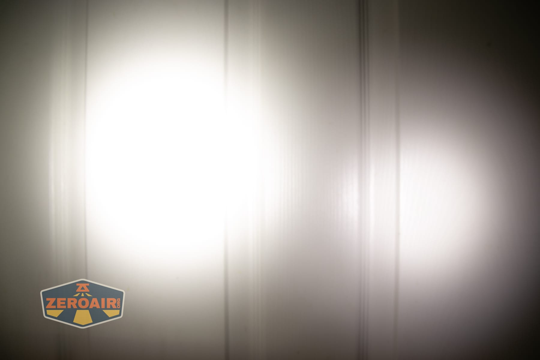 Reylight Dawn Max titanium flashlight beamshots on door (at 1') compared to nichia 219b 4500K